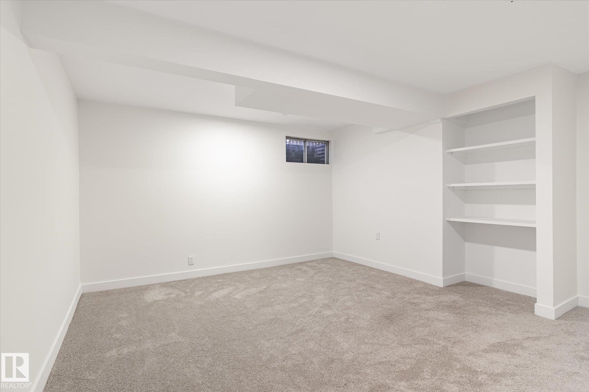 The room features light-colored carpet, white walls, and built-in shelving - 6540 184 Street, Edmonton, AB - Indoor Photo Showing Other Room