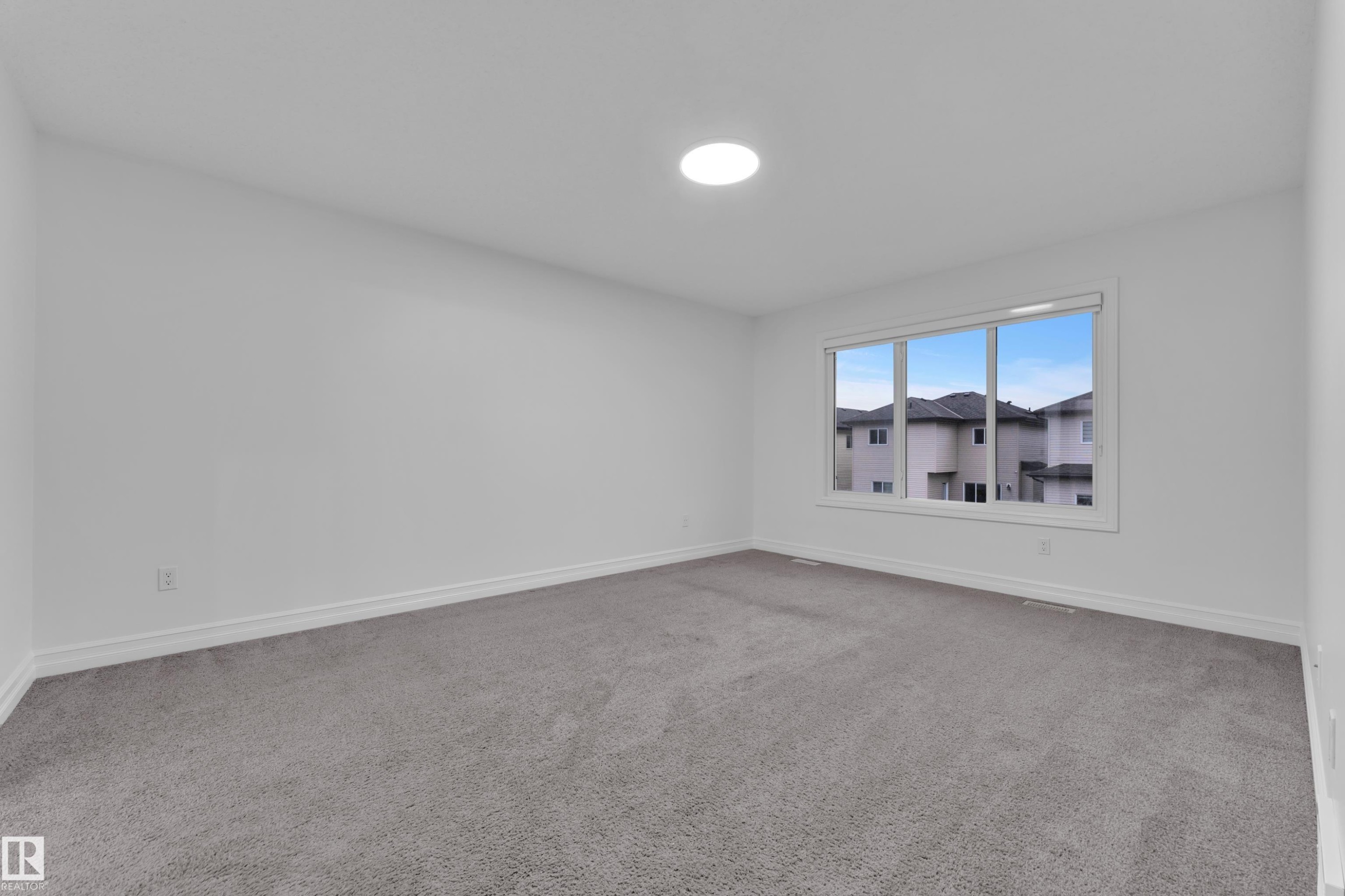 This room features neutral grey carpet and white walls, creating a versatile aesthetic - 3235 13 Avenue, Edmonton, AB - Indoor Photo Showing Other Room