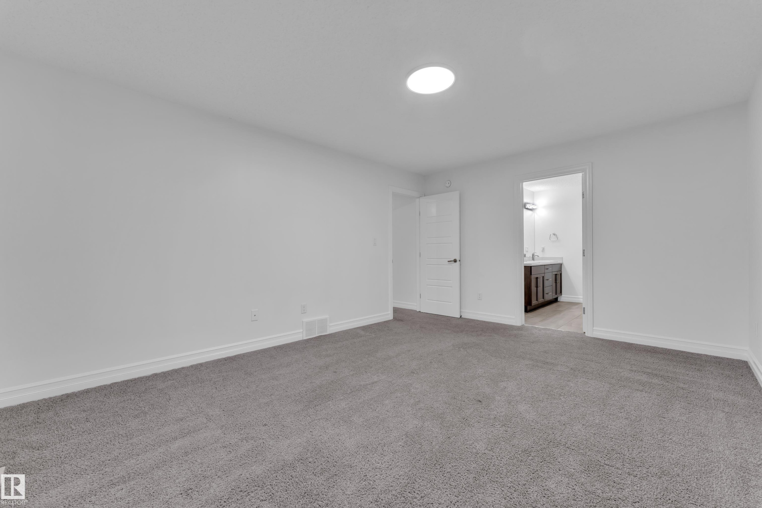 The room features neutral-toned carpeting, white walls, and a circular ceiling light fixture - 3235 13 Avenue, Edmonton, AB - Indoor Photo Showing Other Room