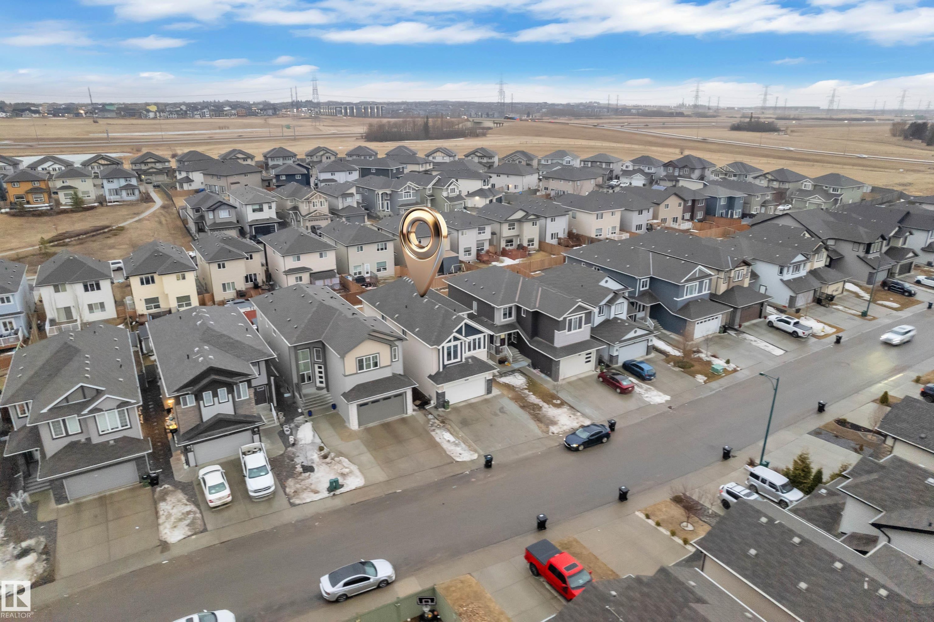 Aerial view showcasing the property within a residential neighborhood featuring detached homes with attached garages, and a clear sky with visible clouds - 3235 13 Avenue, Edmonton, AB - Outdoor With View