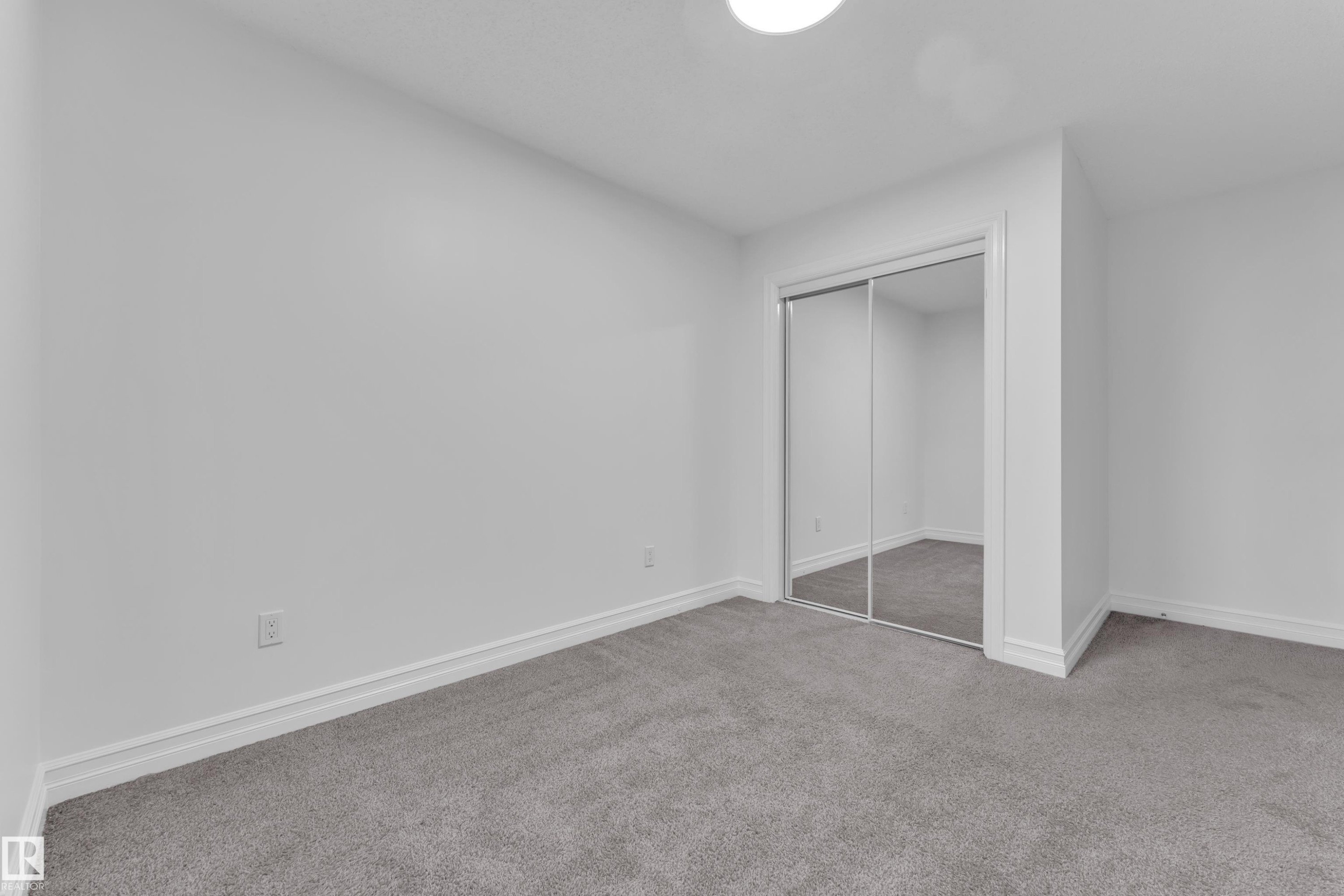 This room features plush grey carpeting and white walls, creating a bright and neutral aesthetic - 3235 13 Avenue, Edmonton, AB - Indoor Photo Showing Other Room