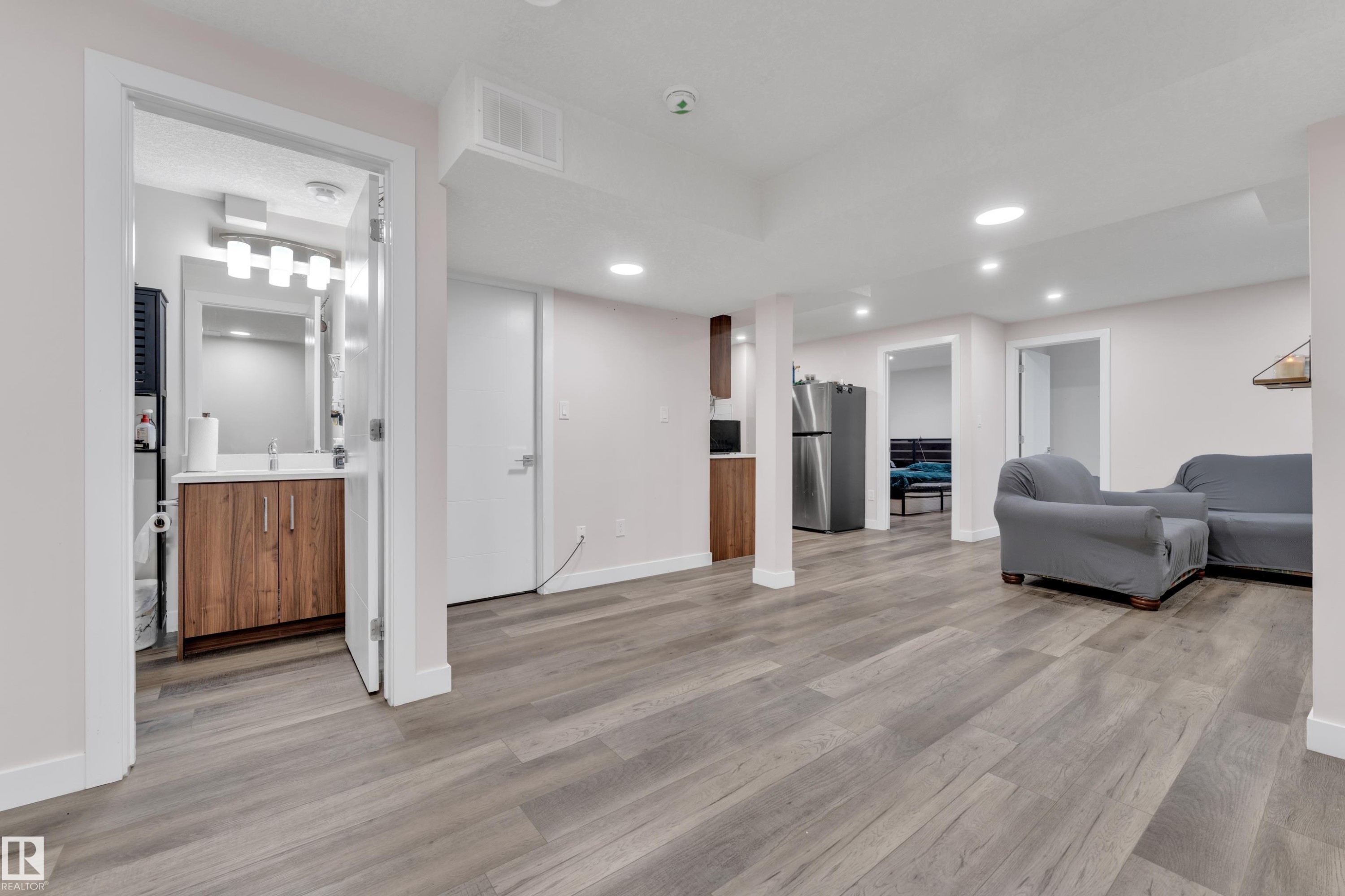This spacious area features light grey flooring, recessed lighting, and a neutral wall color - 3235 13 Avenue, Edmonton, AB - Indoor