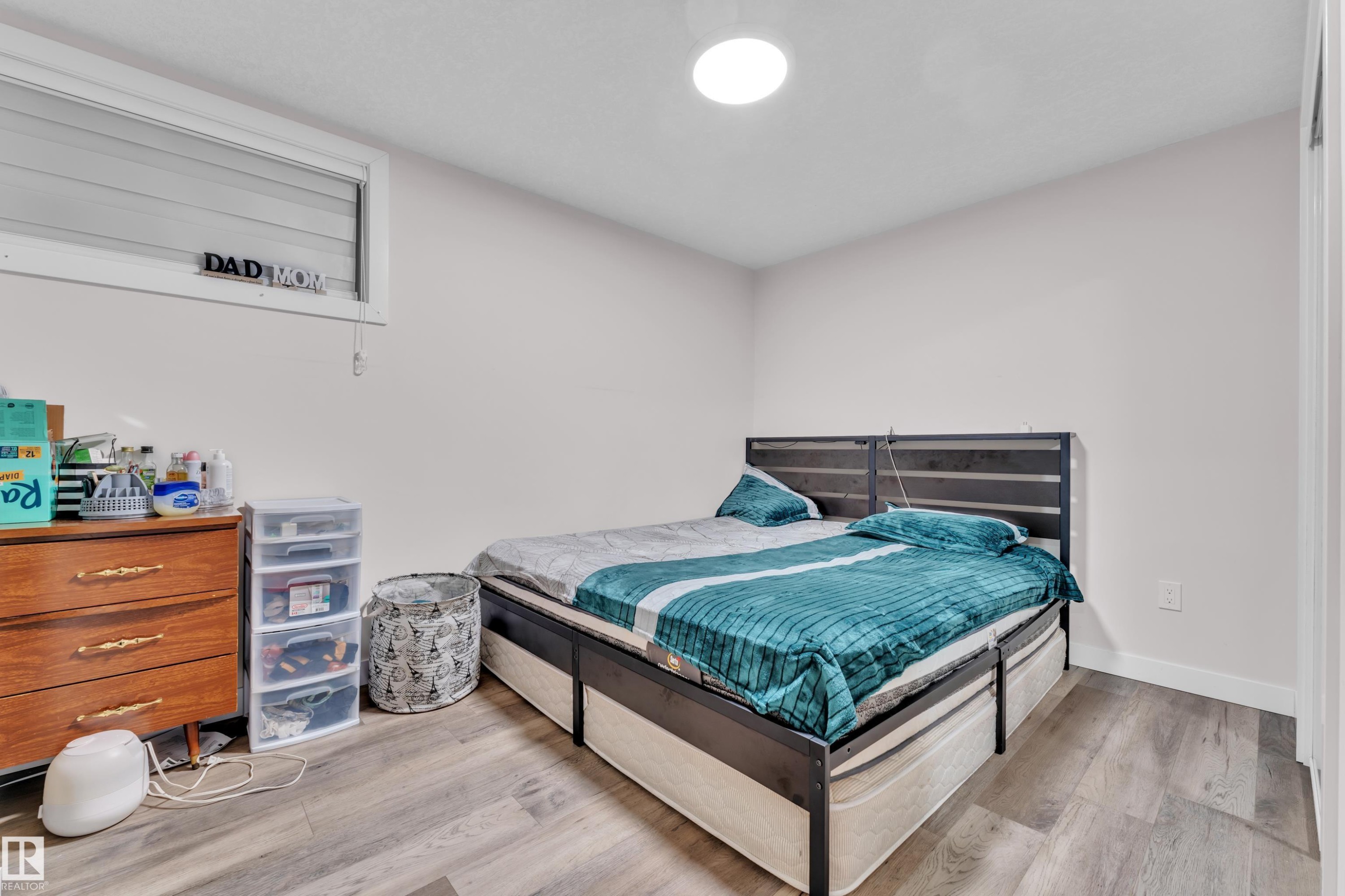 This room features light-colored walls, a window with horizontal blinds, and wood-look flooring - 3235 13 Avenue, Edmonton, AB - Indoor Photo Showing Bedroom