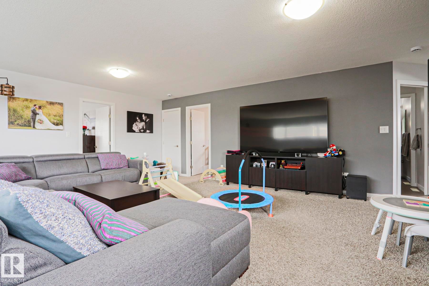 This room features light-colored carpet flooring and a neutral color palette with white and gray walls - 18 Enchanted Way, St. Albert, AB