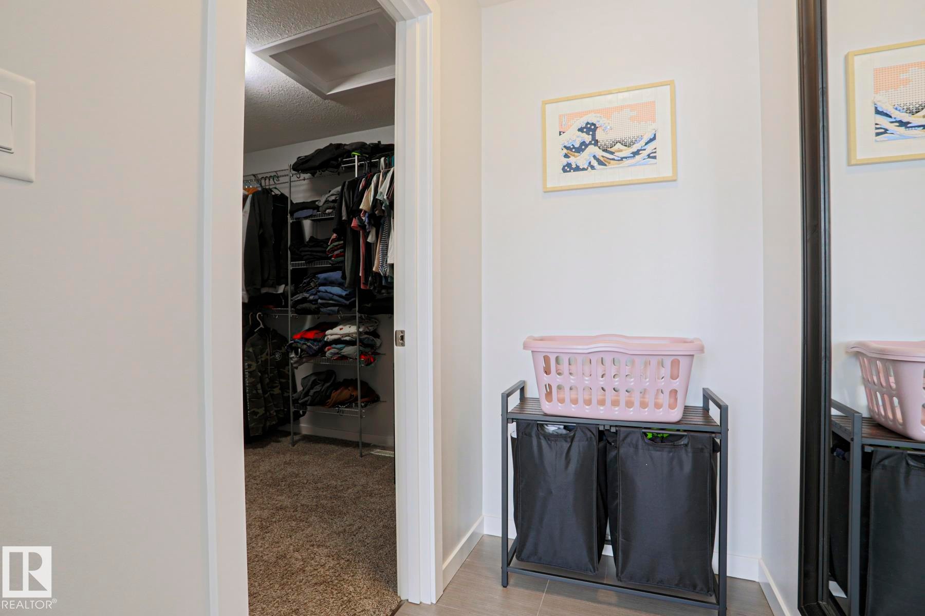 The property includes a walk-in closet with carpet flooring and organized shelving - 18 Enchanted Way, St. Albert, AB
