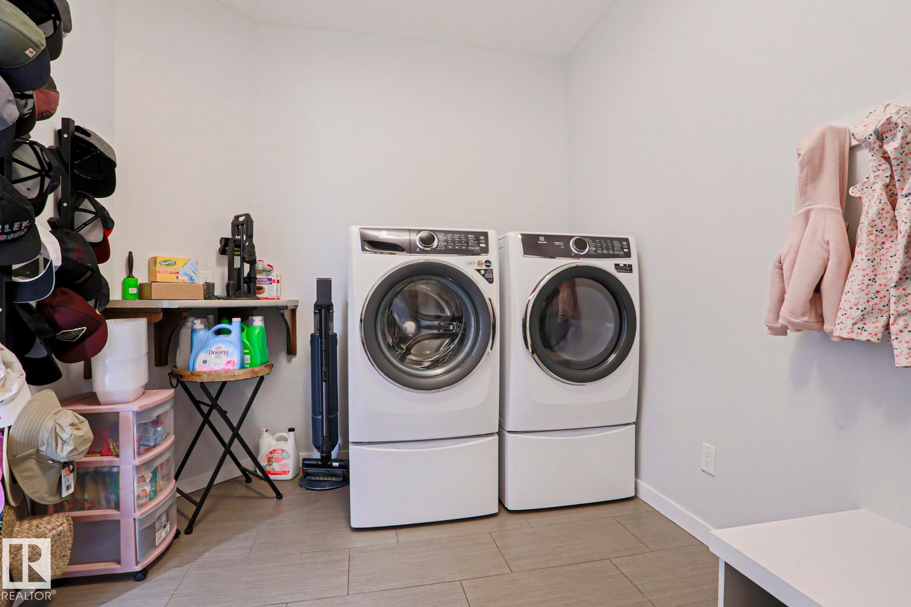 Laundry area featuring a side-by-side washer and dryer, tile flooring, and light-colored walls - 18 Enchanted Way, St. Albert, AB