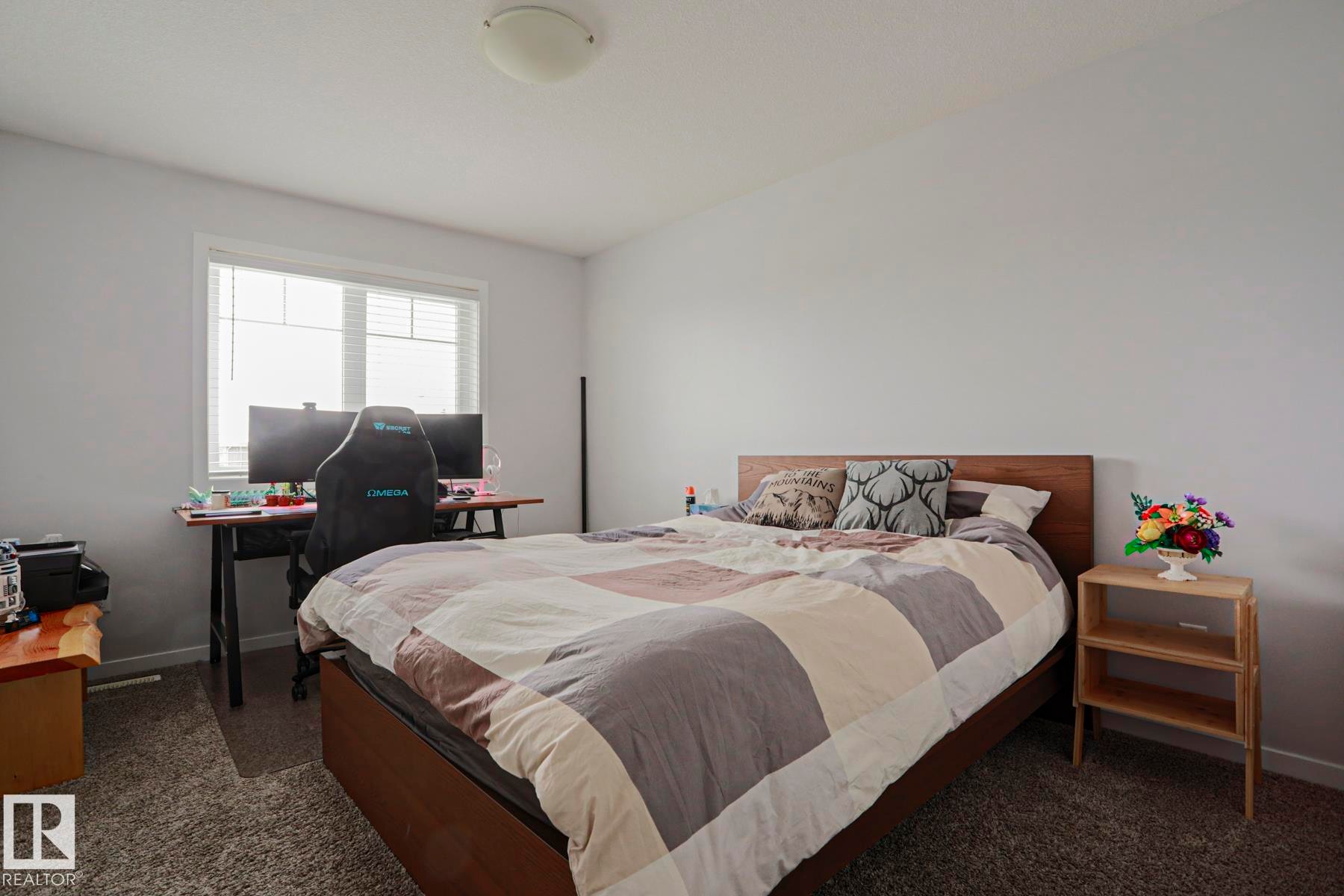 This bright room features a window with blinds, light-colored walls, and a ceiling light fixture - 18 Enchanted Way, St. Albert, AB