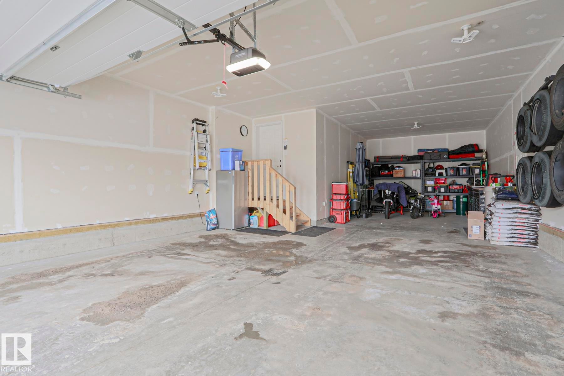 The property features an expansive garage with an automatic garage door opener, providing convenient access - 18 Enchanted Way, St. Albert, AB