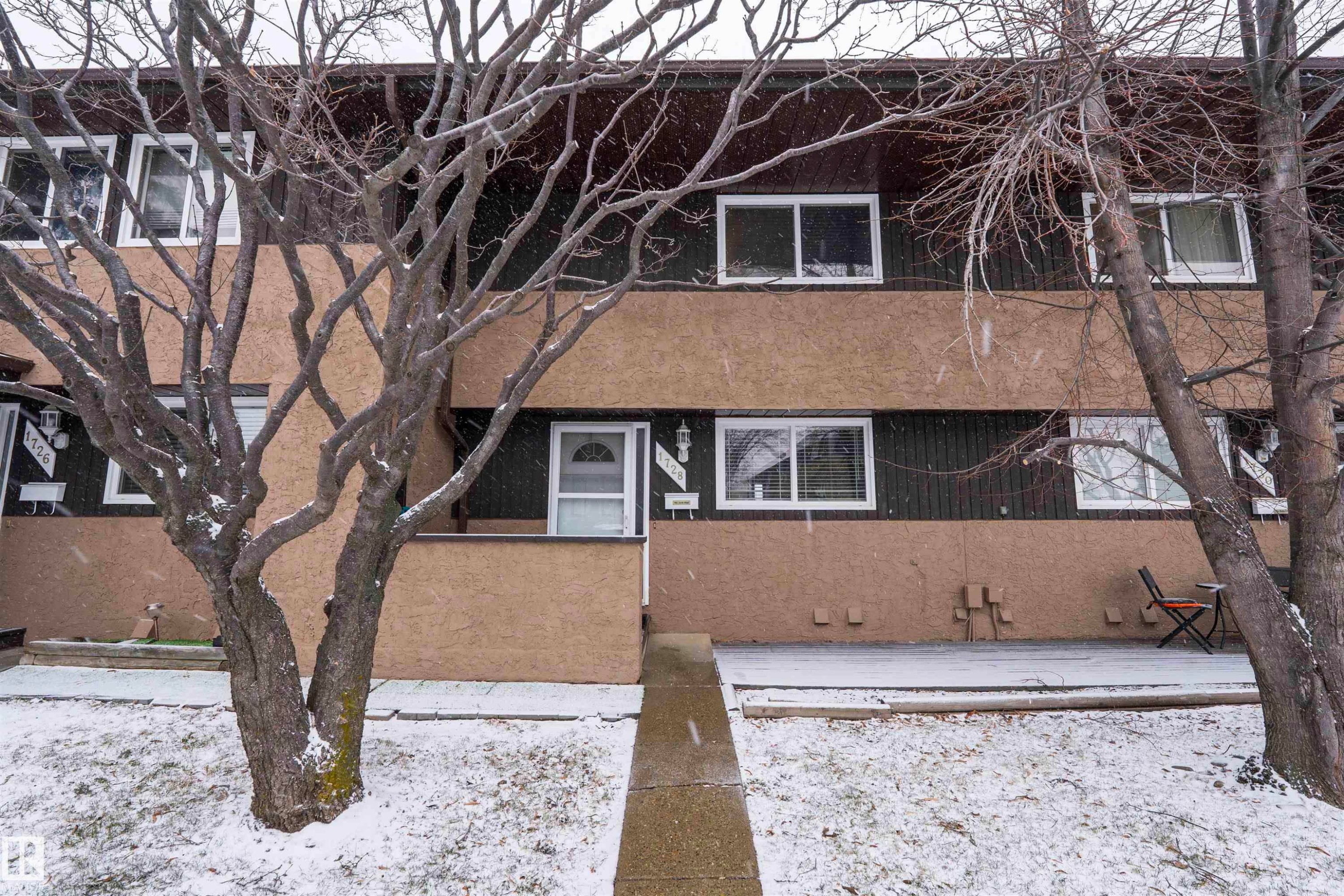 The property exterior features a two-story design, a front entrance with a white door, and several windows - 1728 37 Street, Edmonton, AB - Outdoor