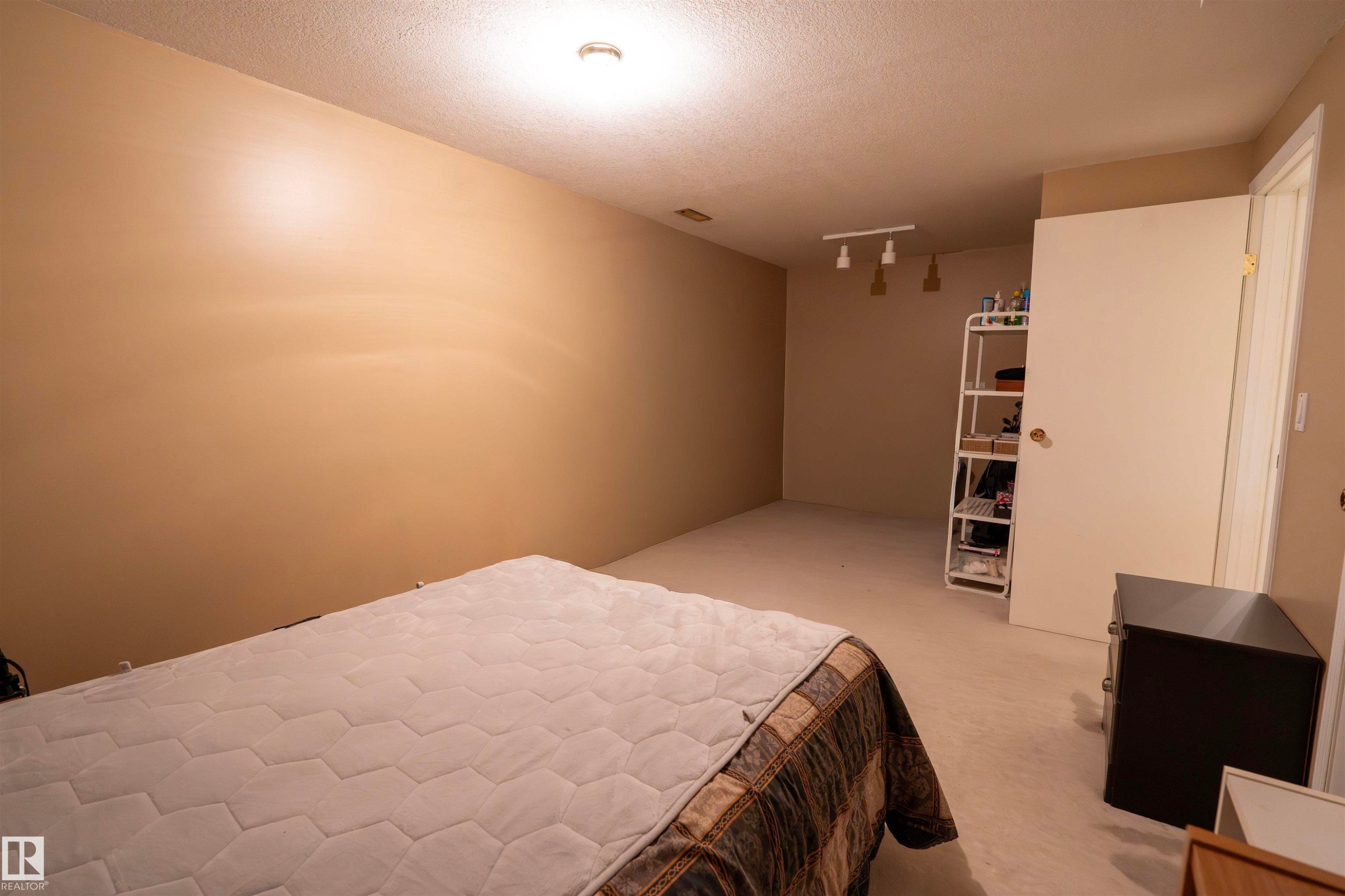 This room features soft neutral tone walls and light-colored carpeting, providing a versatile palette - 1728 37 Street, Edmonton, AB - Indoor Photo Showing Bedroom