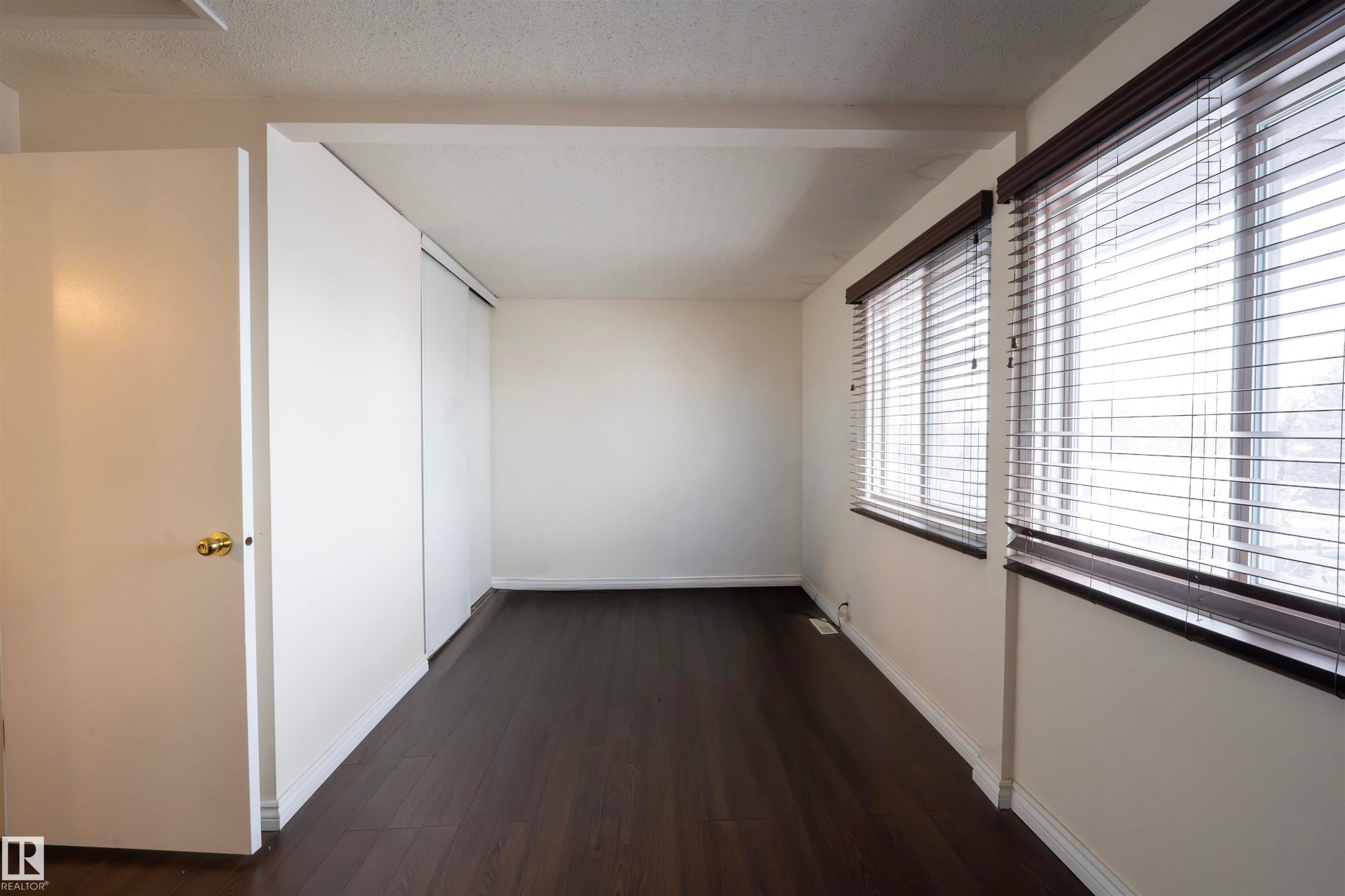 This room features dark flooring, white walls, and windows fitted with horizontal blinds - 1728 37 Street, Edmonton, AB - Indoor Photo Showing Other Room