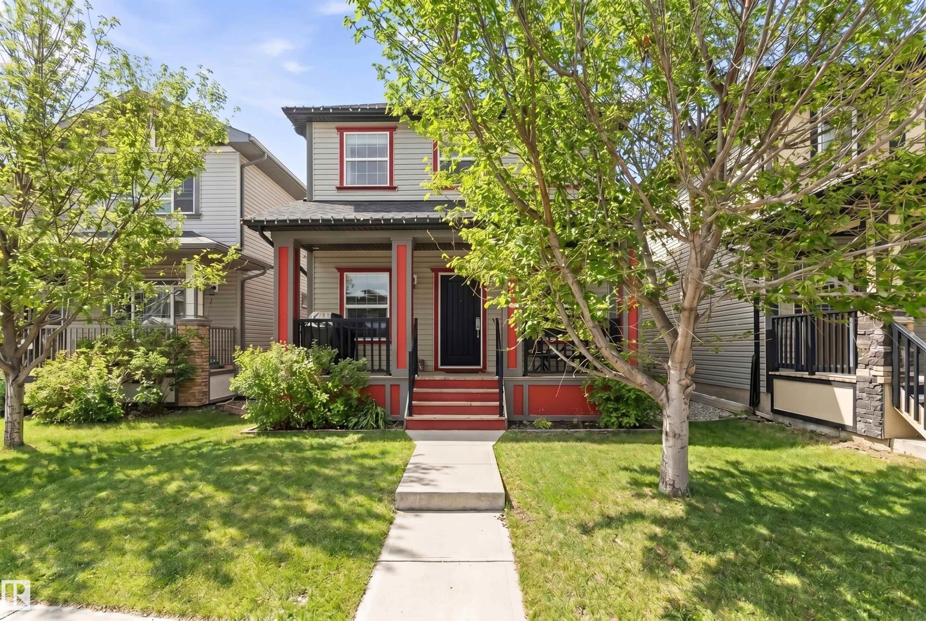 The property features a charming exterior with light-colored siding and red trim accents - 678 Secord Boulevard, Edmonton, AB - Outdoor