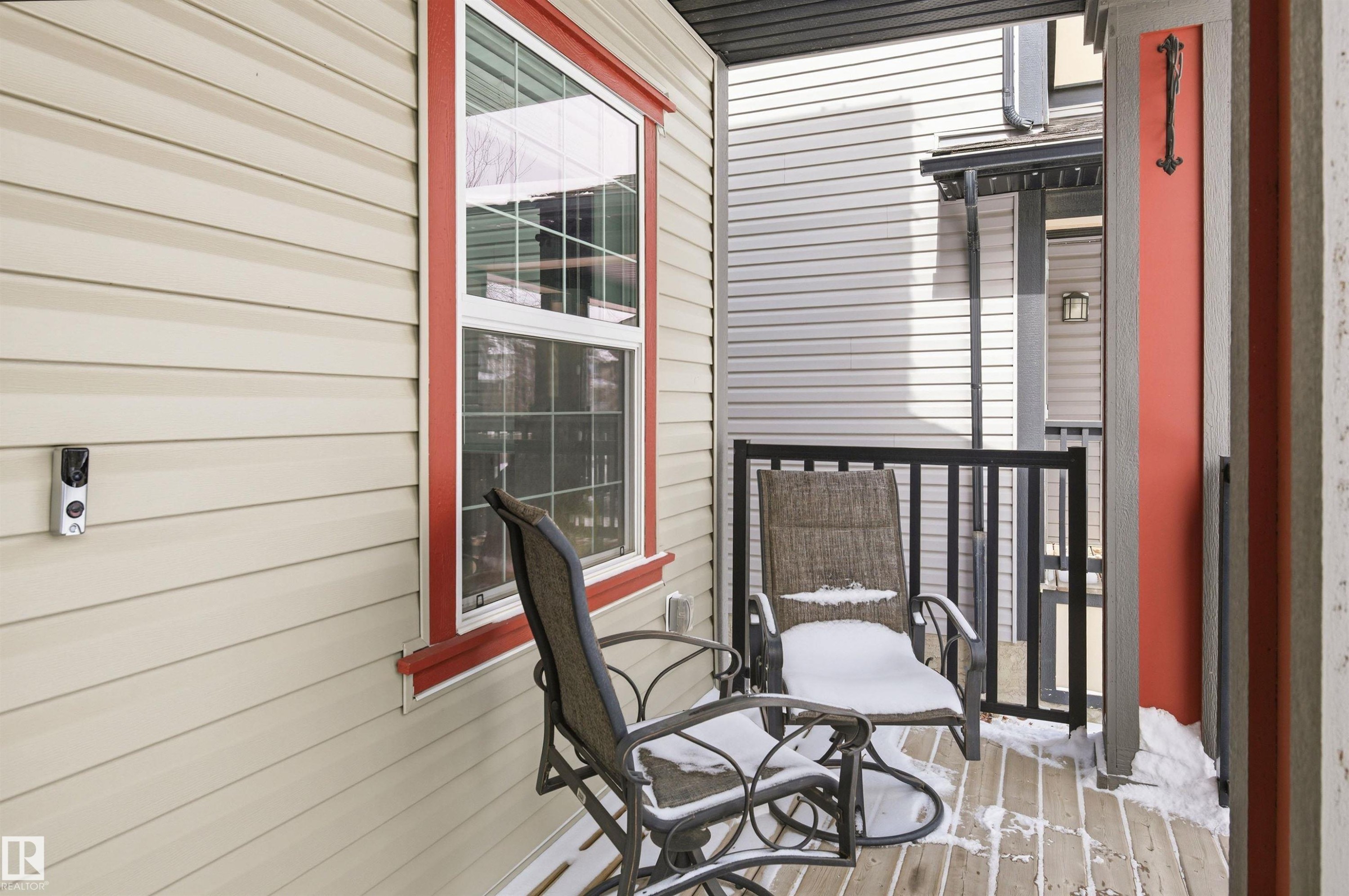 The property features an outdoor patio with wooden decking and a black metal railing - 678 Secord Boulevard, Edmonton, AB - Outdoor With Exterior