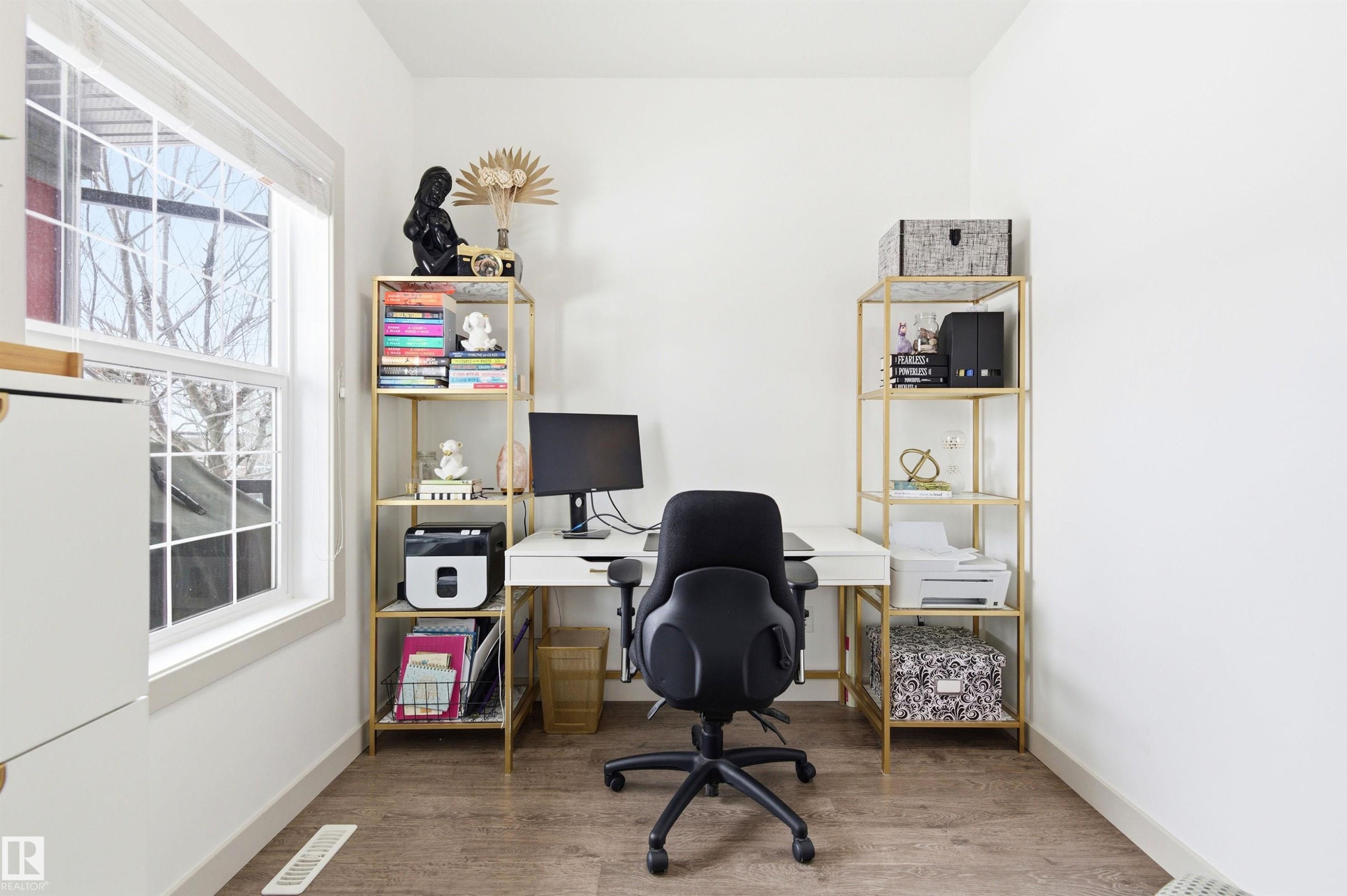 Office space featuring a large window, light-colored walls, and wood-look flooring - 678 Secord Boulevard, Edmonton, AB - Indoor Photo Showing Office