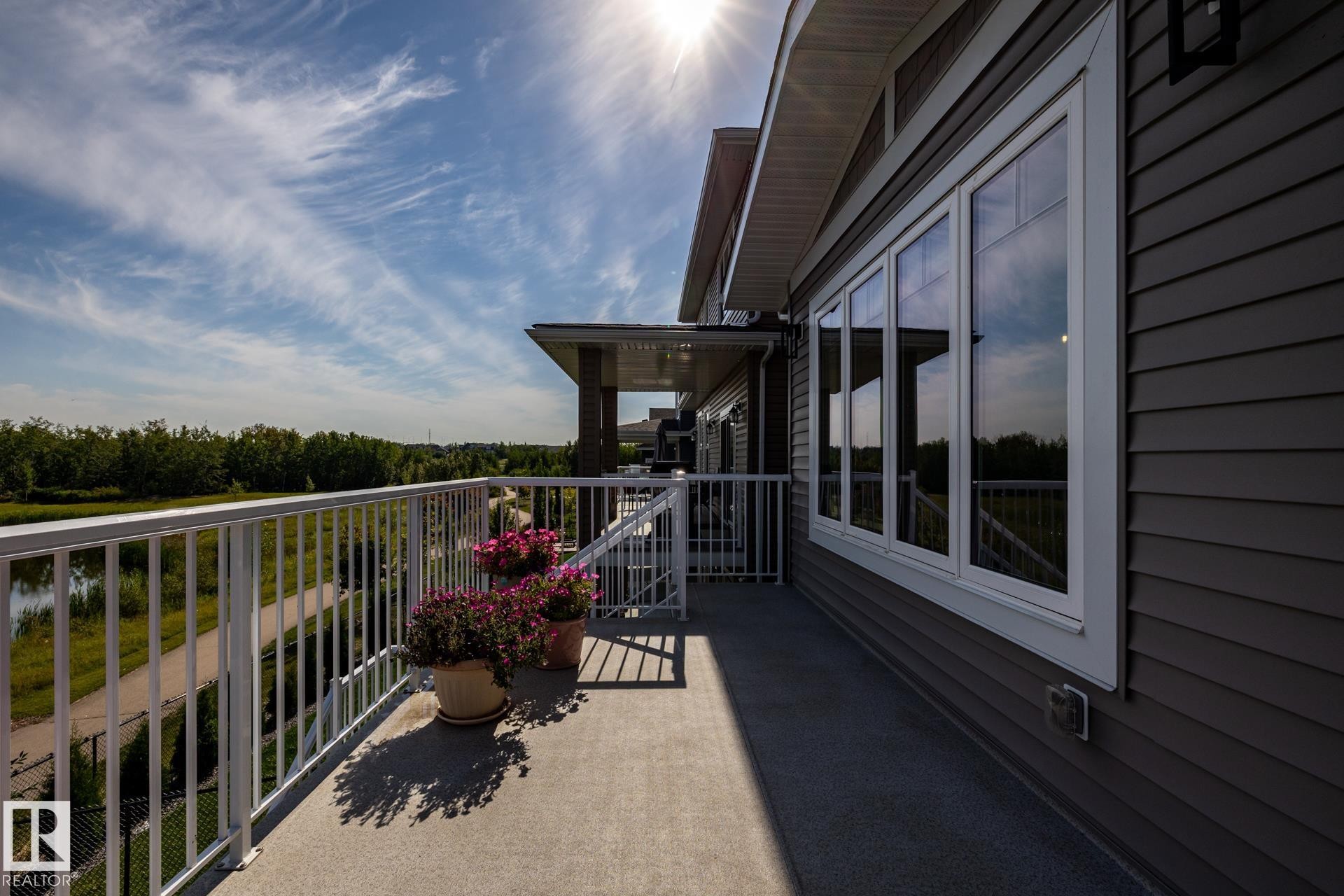 Balcony featuring a durable concrete surface, white metal railing, and extensive exterior siding - 3419 Chickadee Drive, Edmonton, AB - Outdoor With Exterior