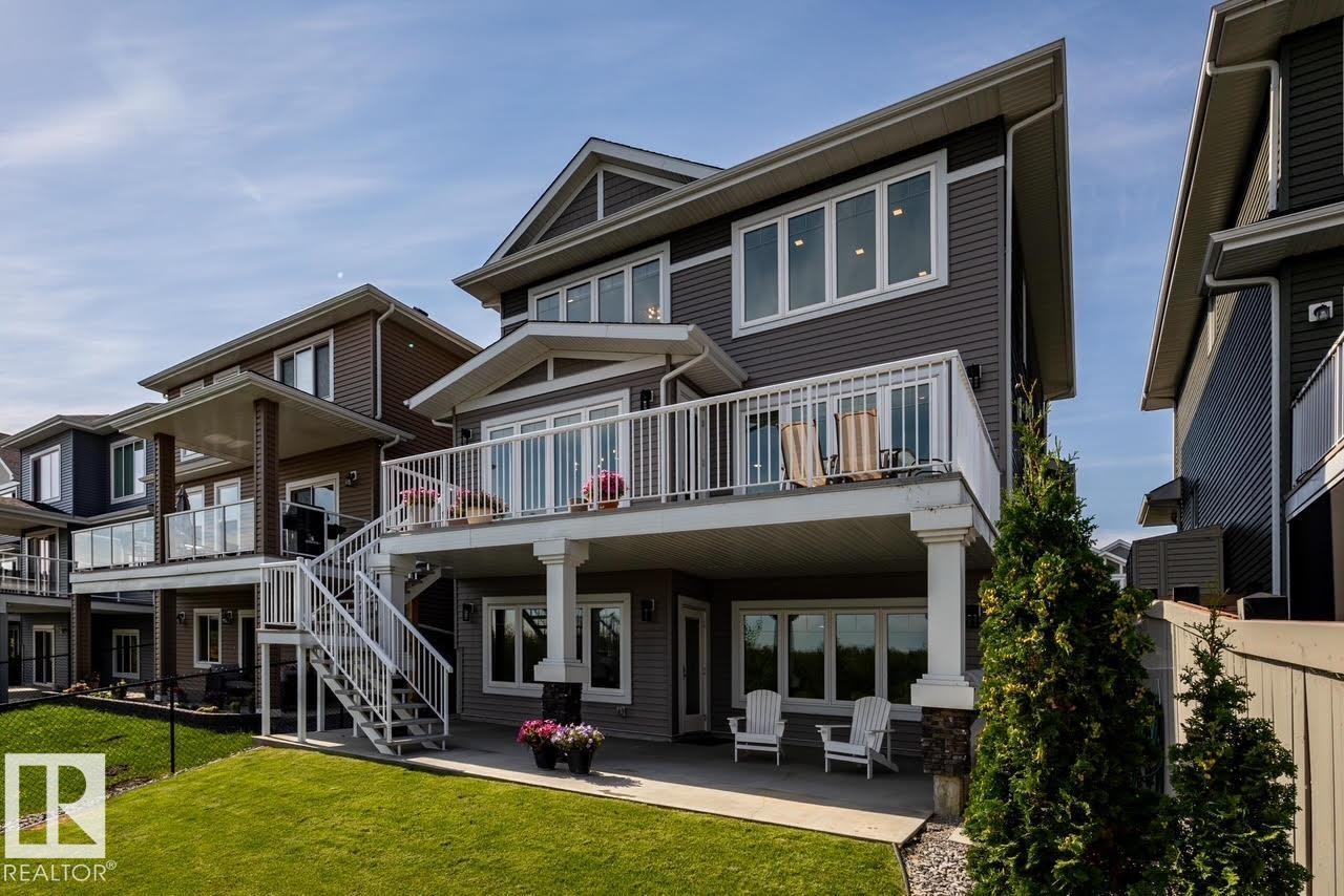 Contemporary multi-level exterior featuring dark gray siding, multiple windows, and a second-story deck with white railings - 3419 Chickadee Drive, Edmonton, AB - Outdoor With Deck Patio Veranda With Facade