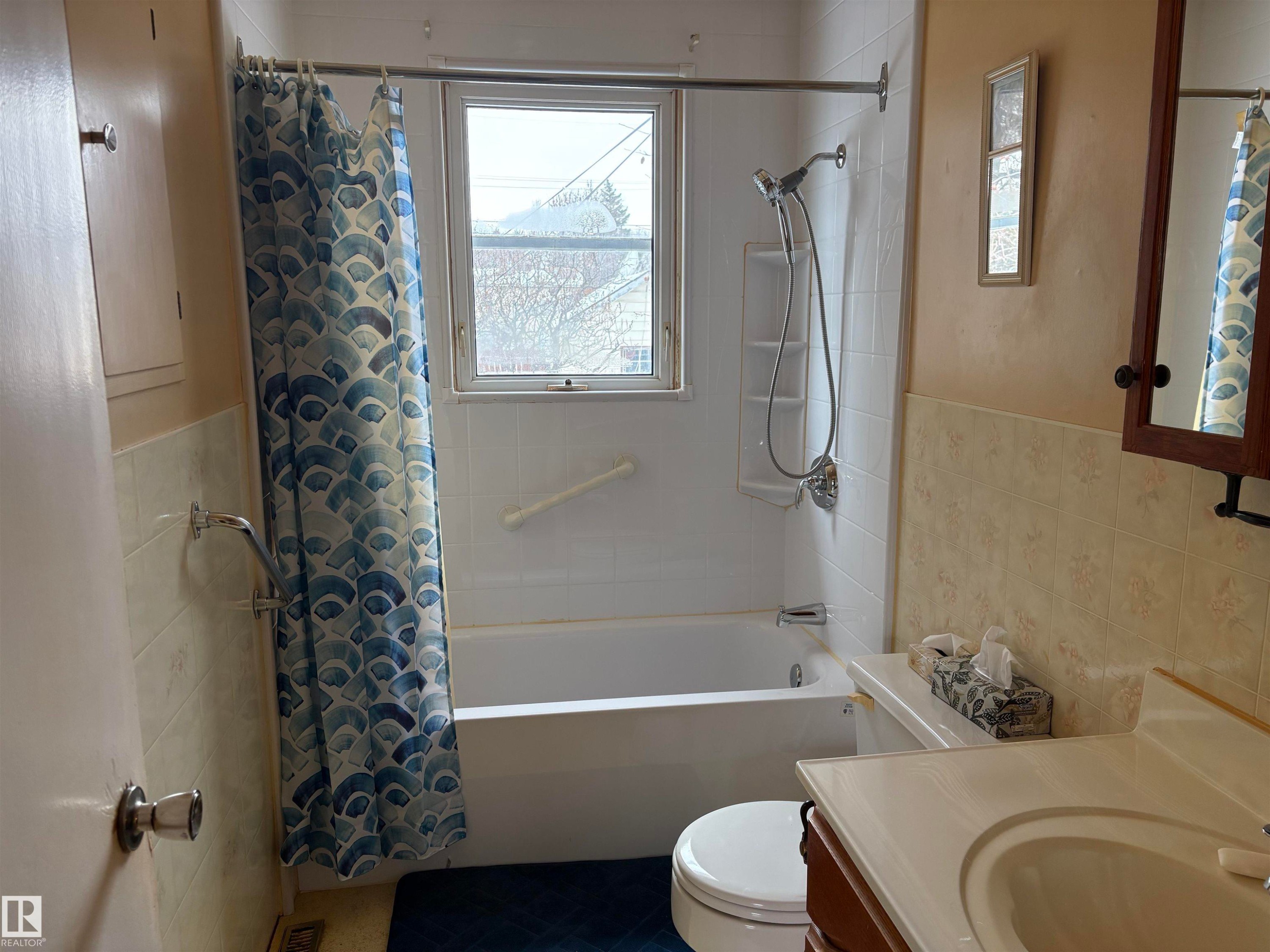 This bathroom features a full bathtub with a showerhead and a window - 10916 151 Street, Edmonton, AB - Indoor Photo Showing Bathroom