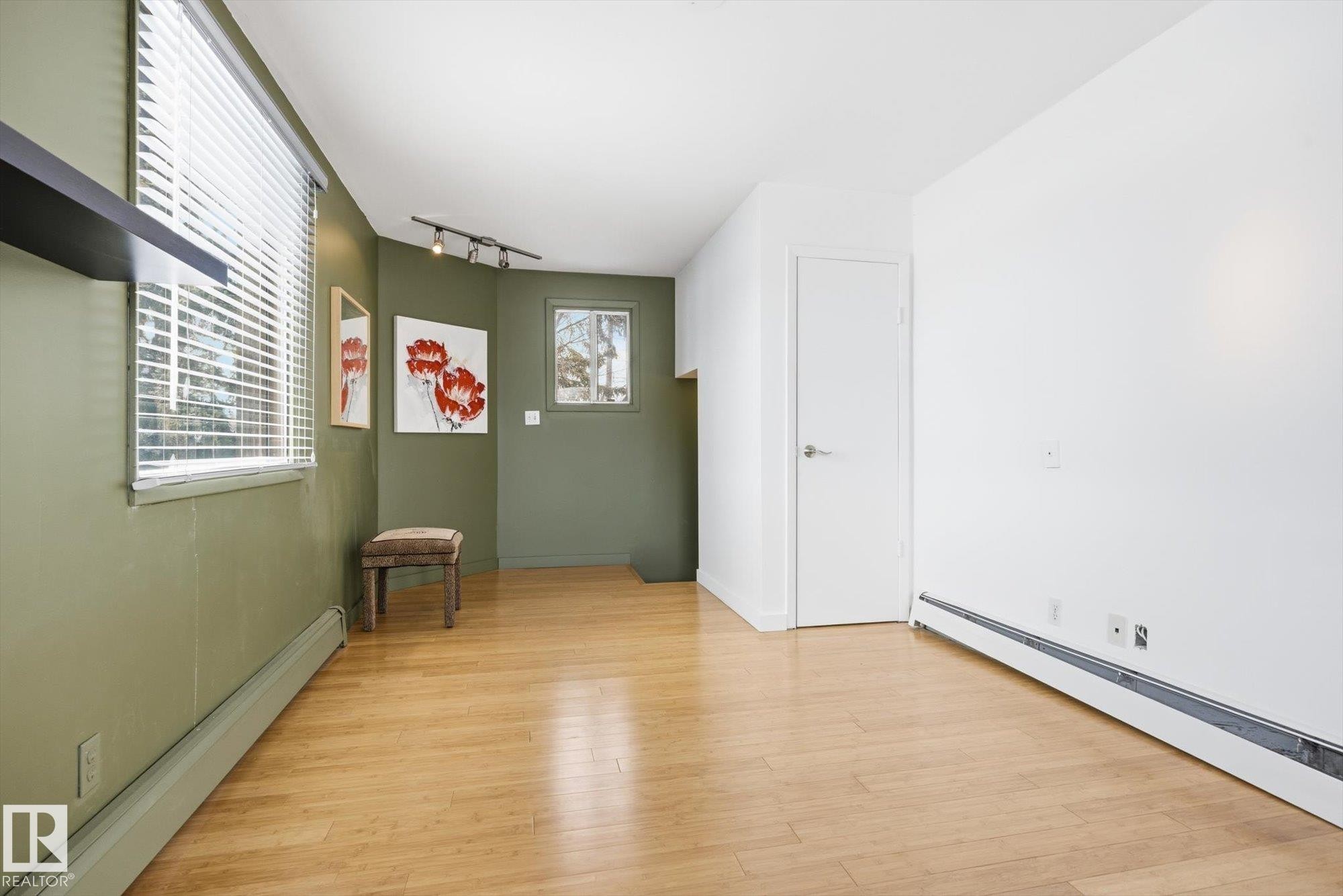 This room features light hardwood flooring, painted walls, and window blinds - 11026 110 Avenue, Edmonton, AB - Indoor Photo Showing Other Room