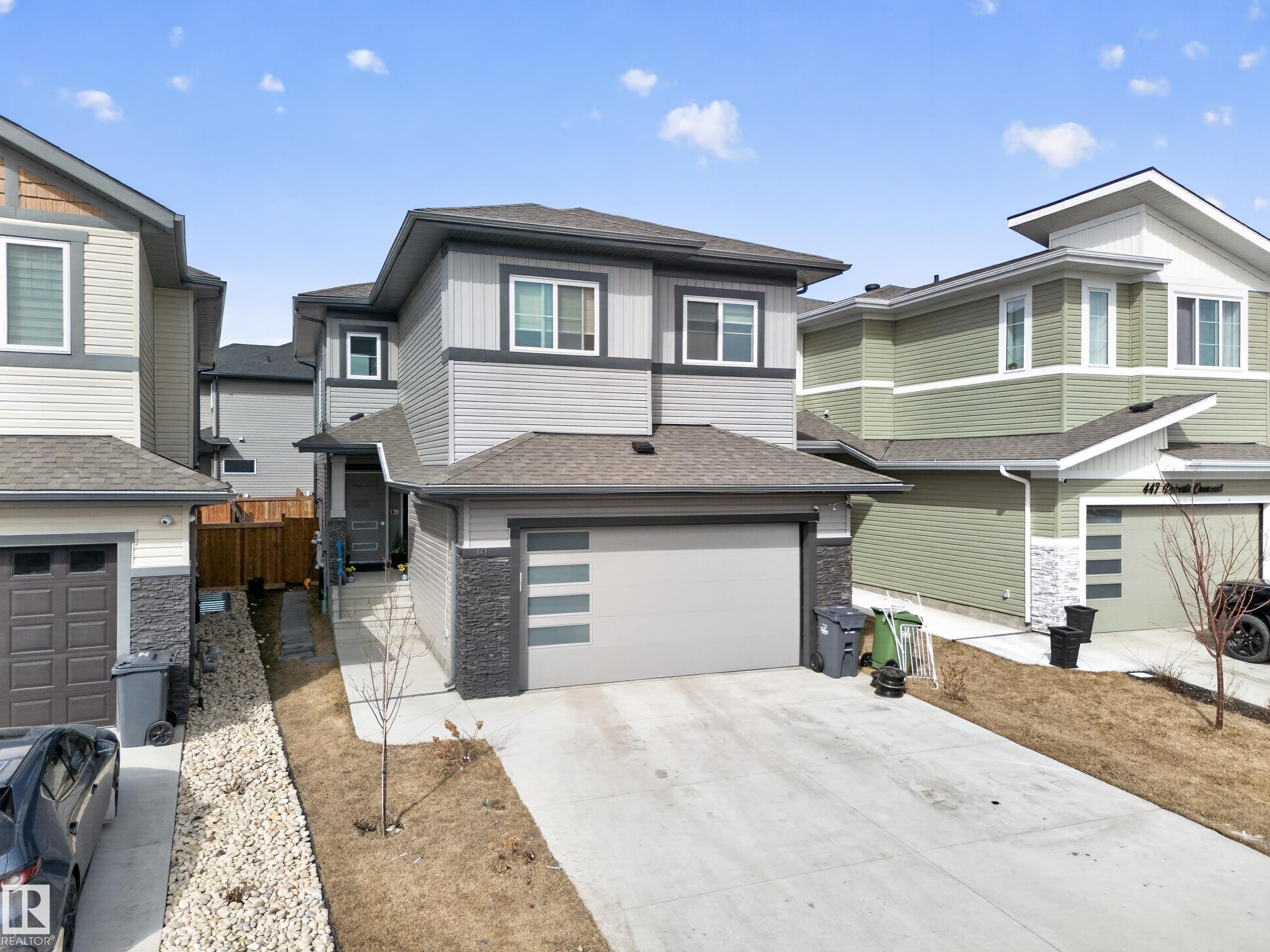 The property features a concrete driveway leading to an attached garage with a modern design - 449 Roberts Crescent, Leduc, AB - Outdoor