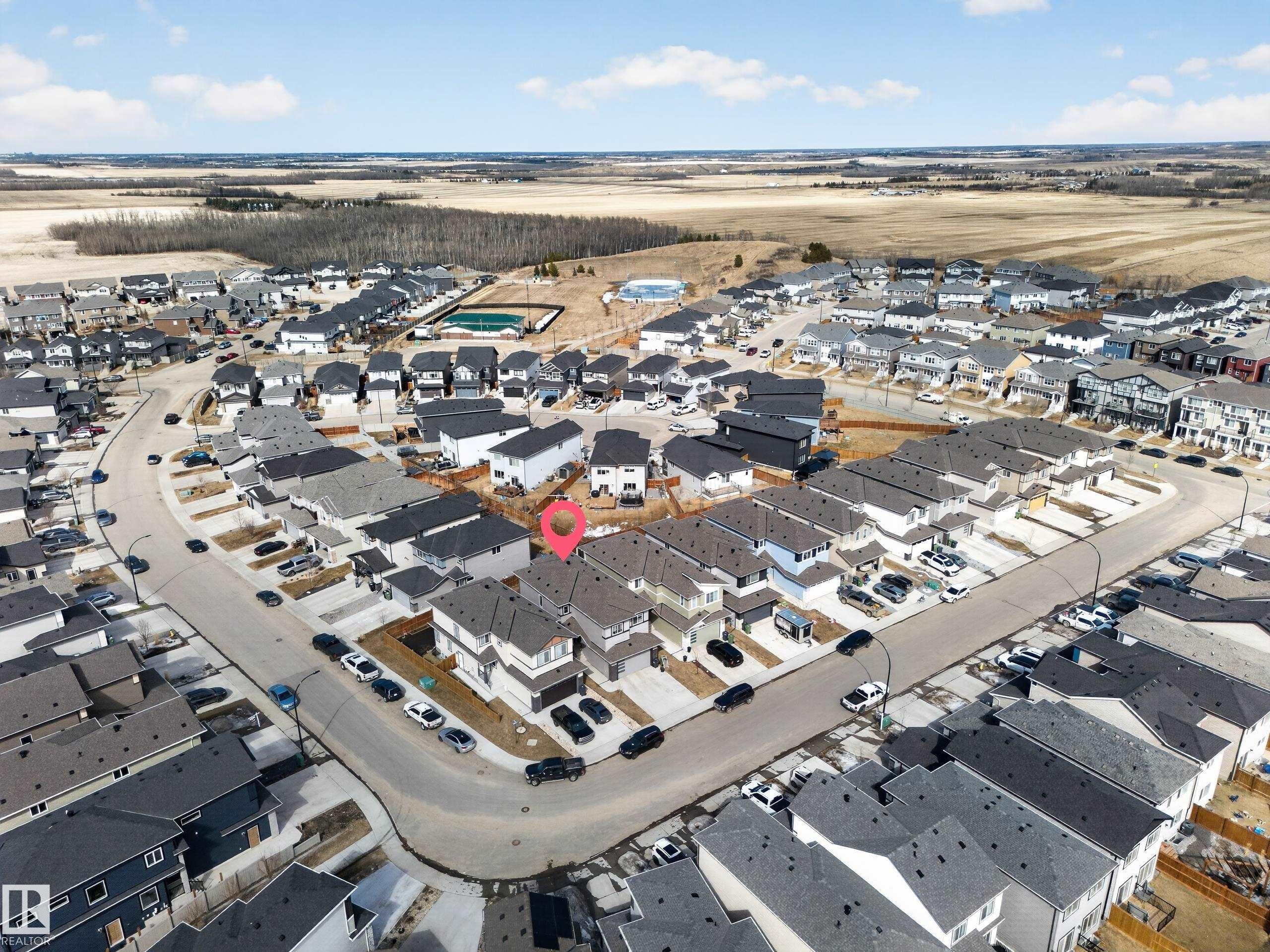 The property is situated within a developed residential community with paved streets and surrounding landscape - 449 Roberts Crescent, Leduc, AB - Outdoor With View