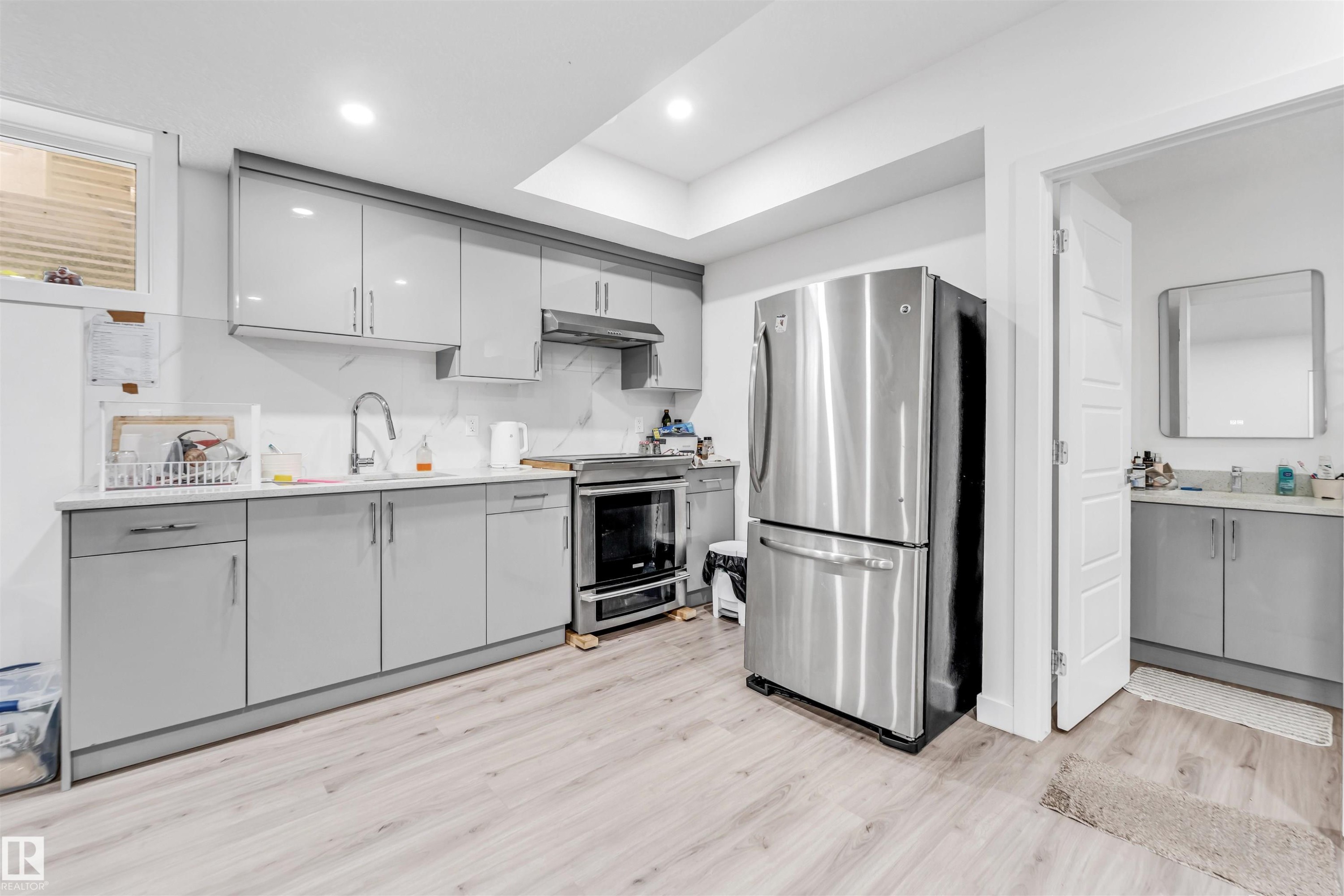 Well-appointed kitchen featuring light-toned cabinetry, stainless steel appliances, and light-colored flooring - 449 Roberts Crescent, Leduc, AB - Indoor Photo Showing Kitchen