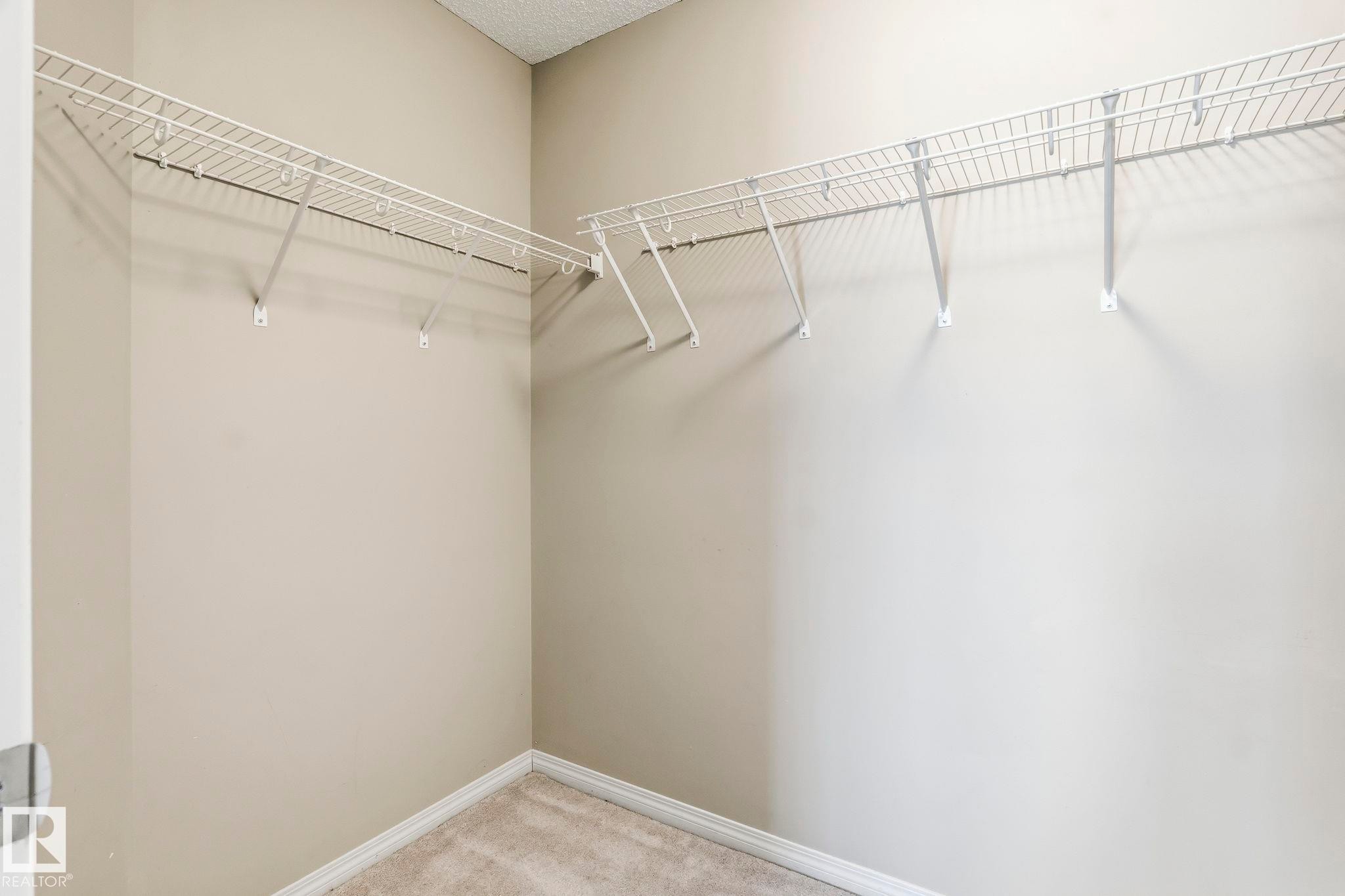 The closet features wire shelving and neutral-toned walls, complemented by a carpeted floor - 4783 Crabapplle Run, Edmonton, AB - Indoor With Storage