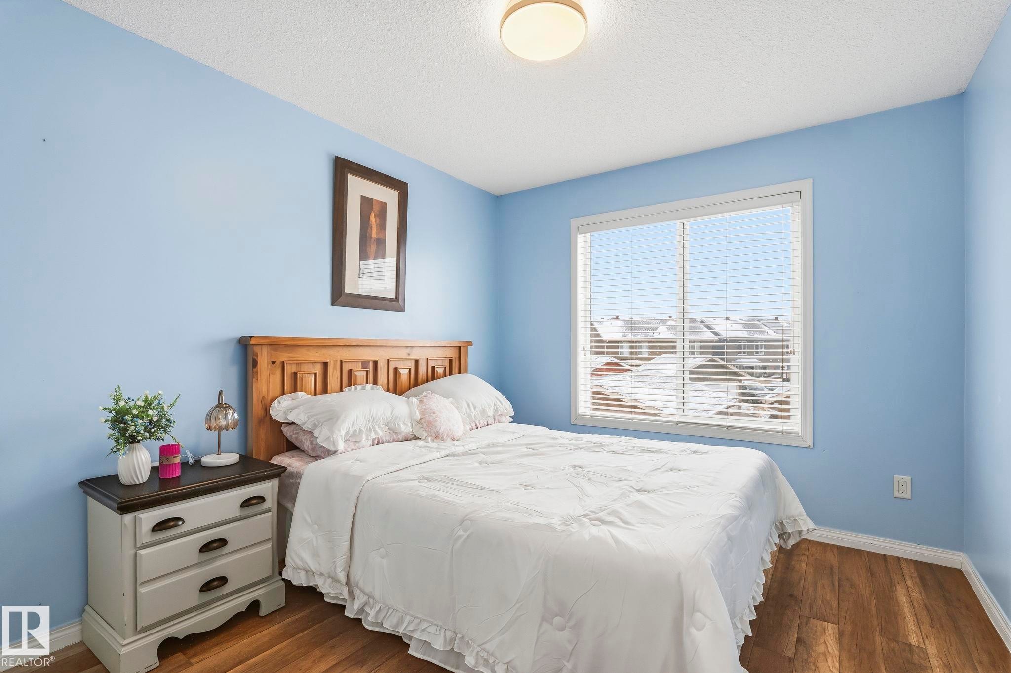 The room features durable hardwood flooring and a ceiling-mounted light fixture, providing illumination - 4783 Crabapplle Run, Edmonton, AB - Indoor Photo Showing Bedroom