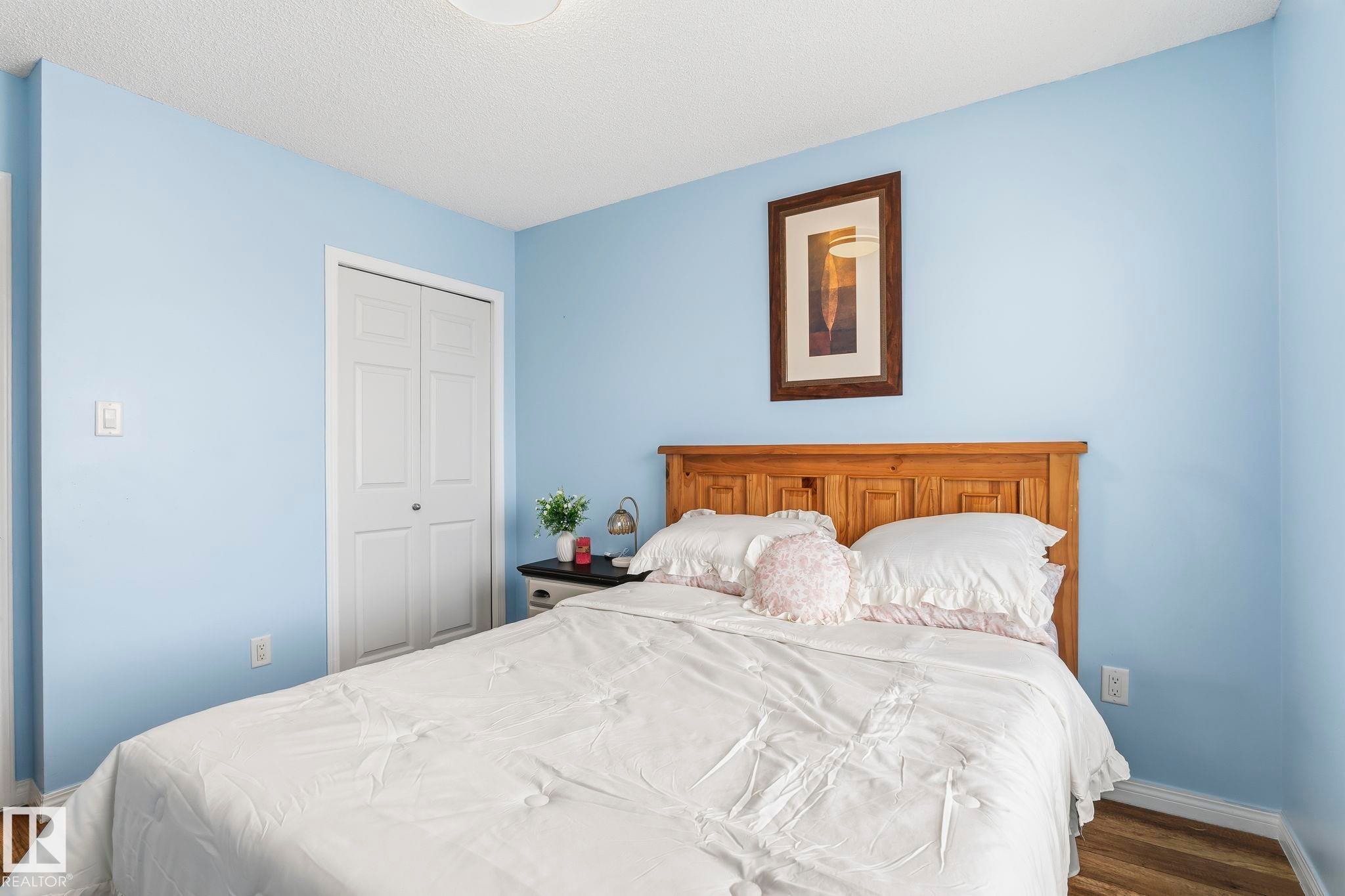This room features light blue walls, a white ceiling, and hardwood flooring - 4783 Crabapplle Run, Edmonton, AB - Indoor Photo Showing Bedroom
