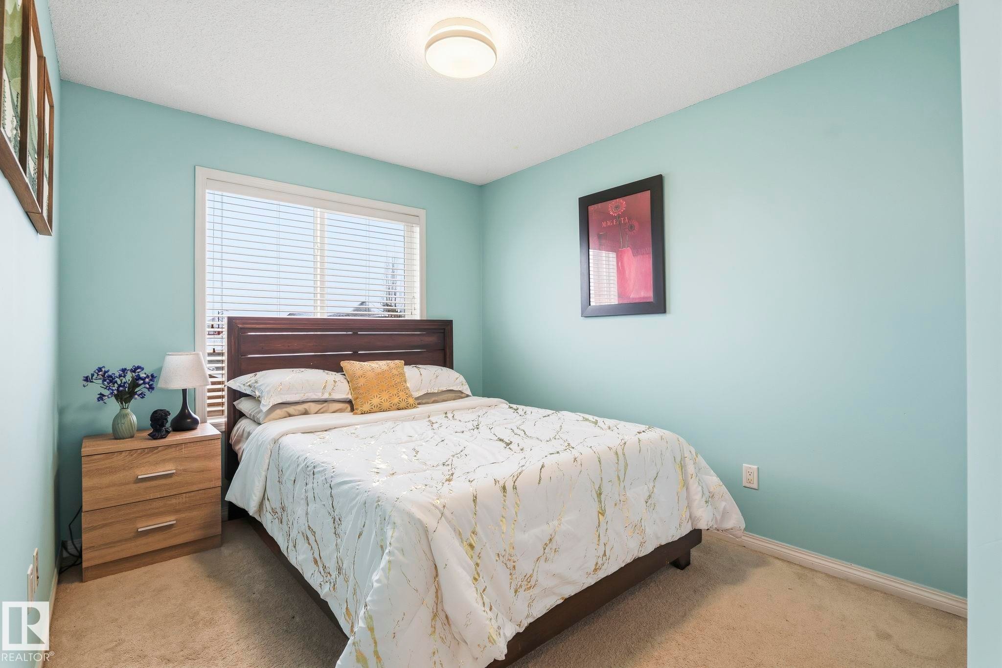 This room features light blue walls, a window with blinds, and beige carpeting - 4783 Crabapplle Run, Edmonton, AB - Indoor Photo Showing Bedroom