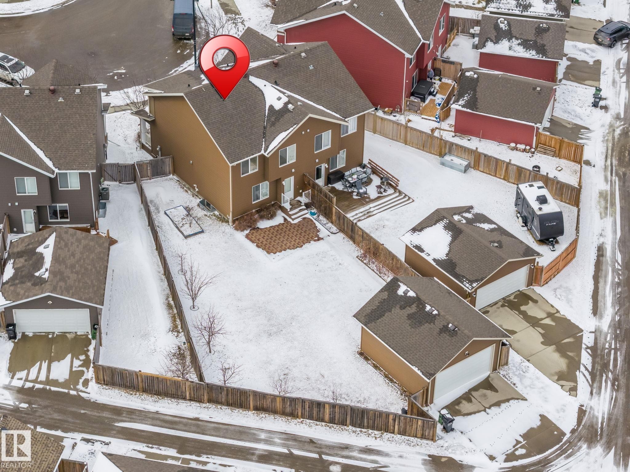 The property features a spacious backyard with a patio area and two detached garage structures - 4783 Crabapplle Run, Edmonton, AB - Outdoor