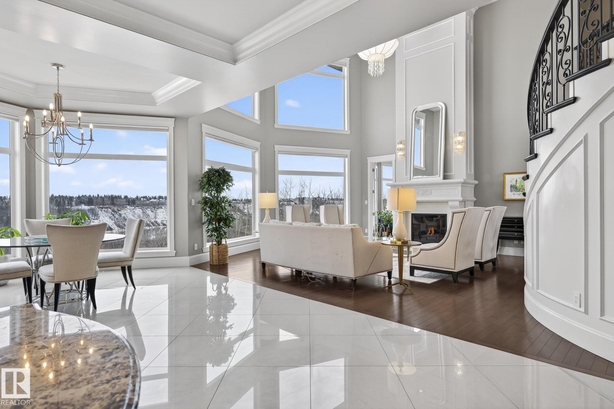 Expansive living area showcasing high ceilings, large windows providing abundant natural light, a fireplace with a decorative mantel, and a grand staircase with an ornate railing - 1413 Woodward Crescent, Edmonton, AB - Indoor Photo Showing Dining Room