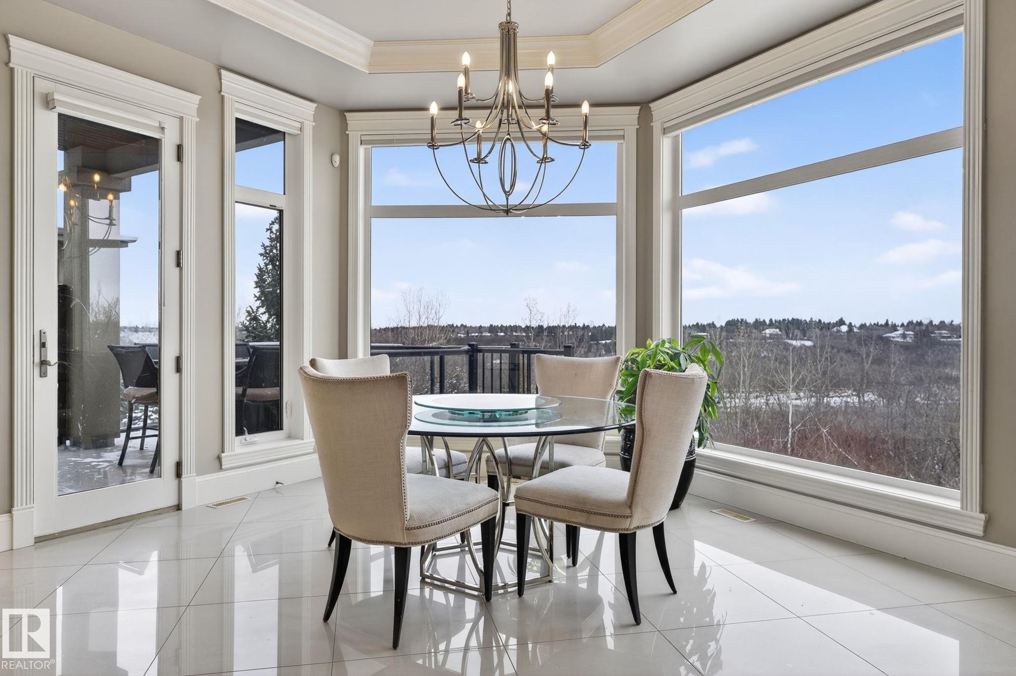 This dining area features large windows offering extensive outdoor views, a chandelier, and polished tile flooring - 1413 Woodward Crescent, Edmonton, AB - Indoor Photo Showing Dining Room