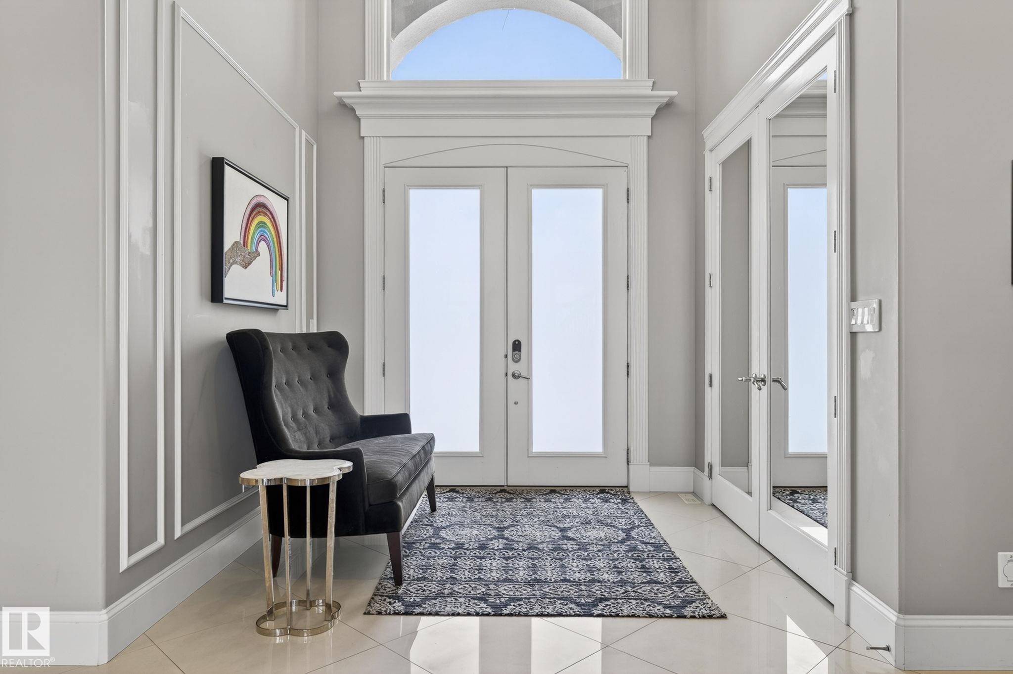 The entrance features a double door with glass panels and an arched transom window above, set against a light-colored wall with decorative molding - 1413 Woodward Crescent, Edmonton, AB - Indoor Photo Showing Other Room