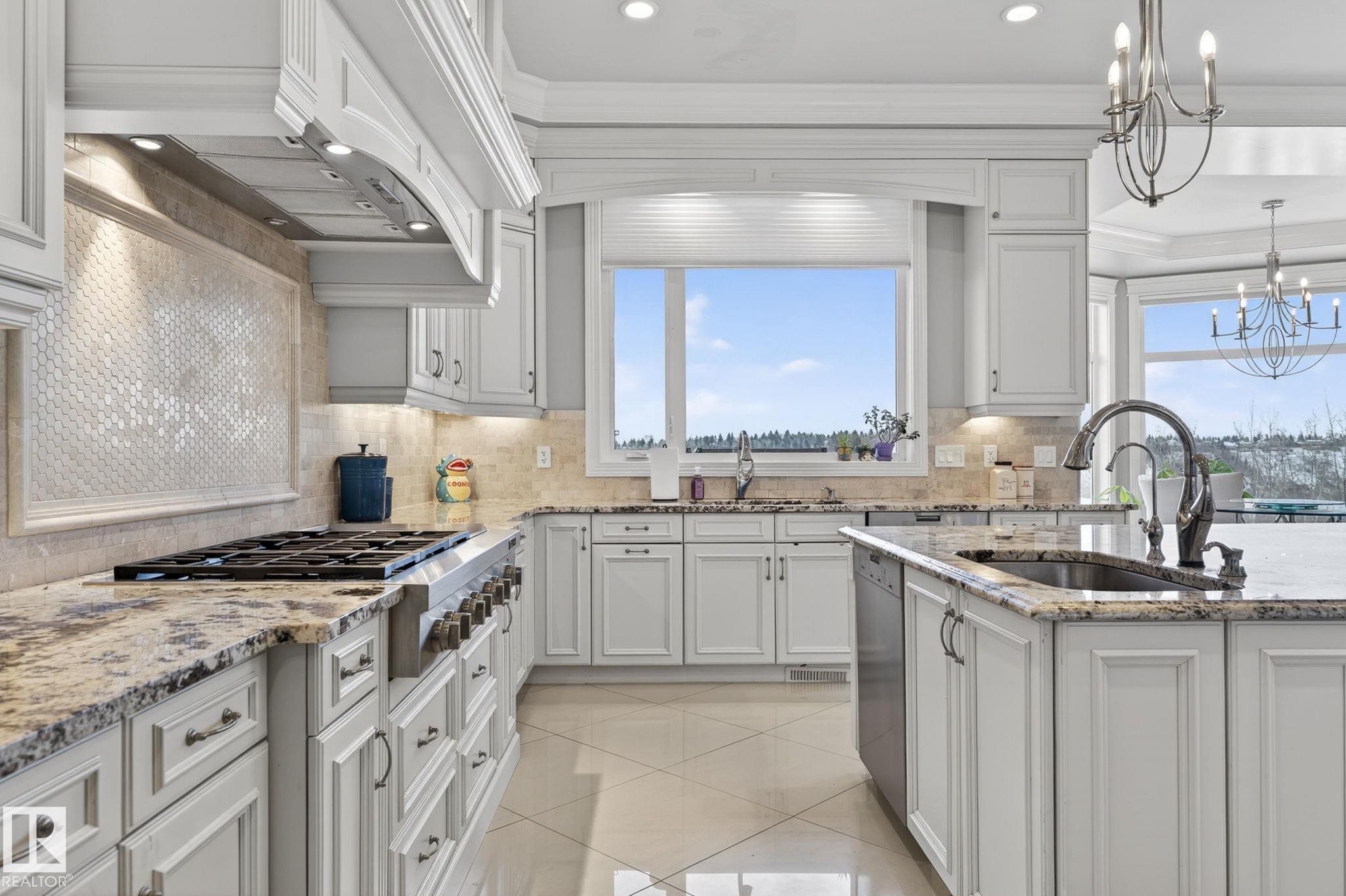 The kitchen features white cabinetry, granite countertops, a built-in range, a tile backsplash, and a window above the sink - 1413 Woodward Crescent, Edmonton, AB - Indoor Photo Showing Kitchen With Upgraded Kitchen