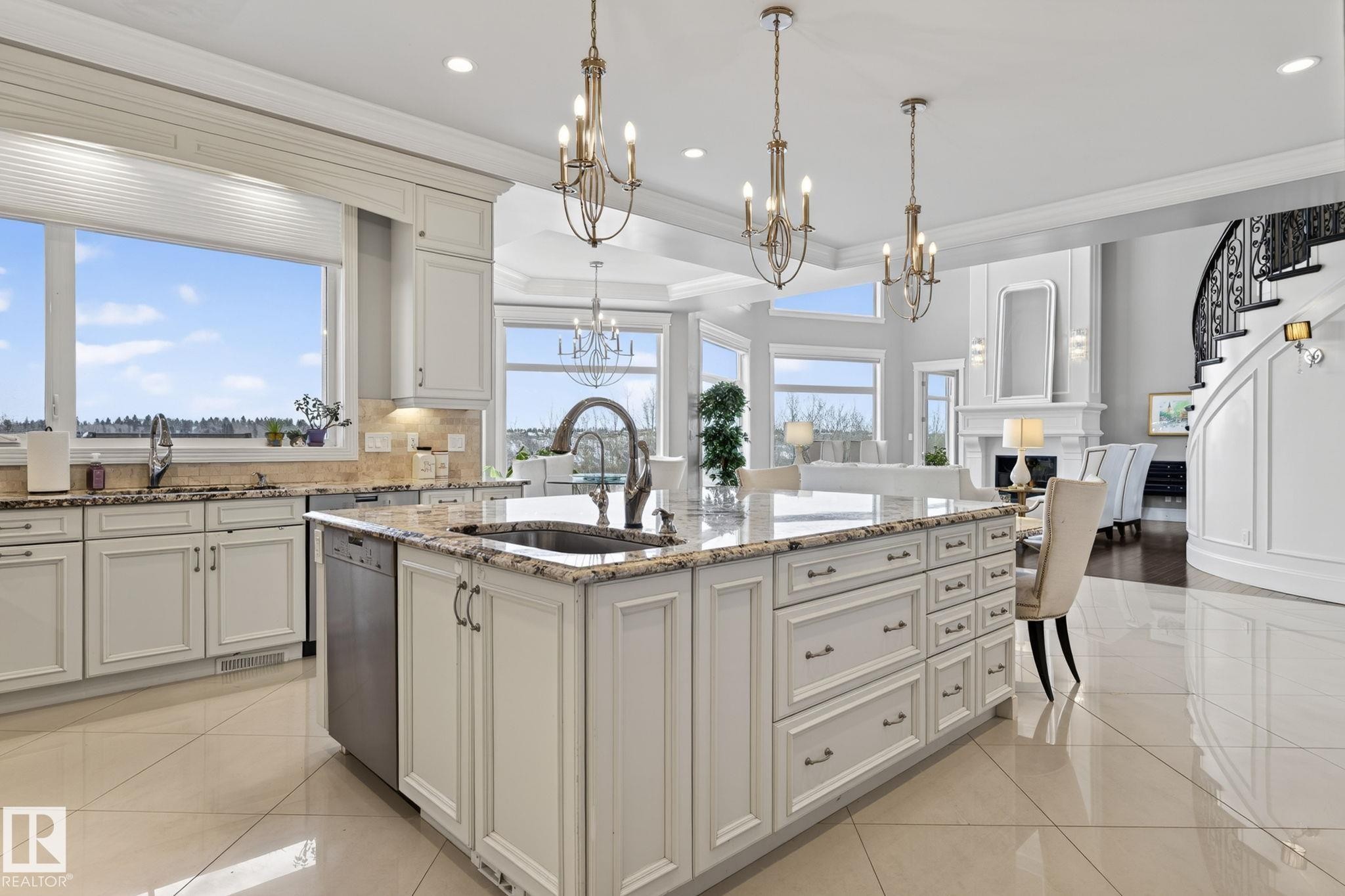 The kitchen features white cabinetry, granite countertops, a large island with an integrated sink, and polished tile flooring - 1413 Woodward Crescent, Edmonton, AB - Indoor Photo Showing Kitchen With Upgraded Kitchen