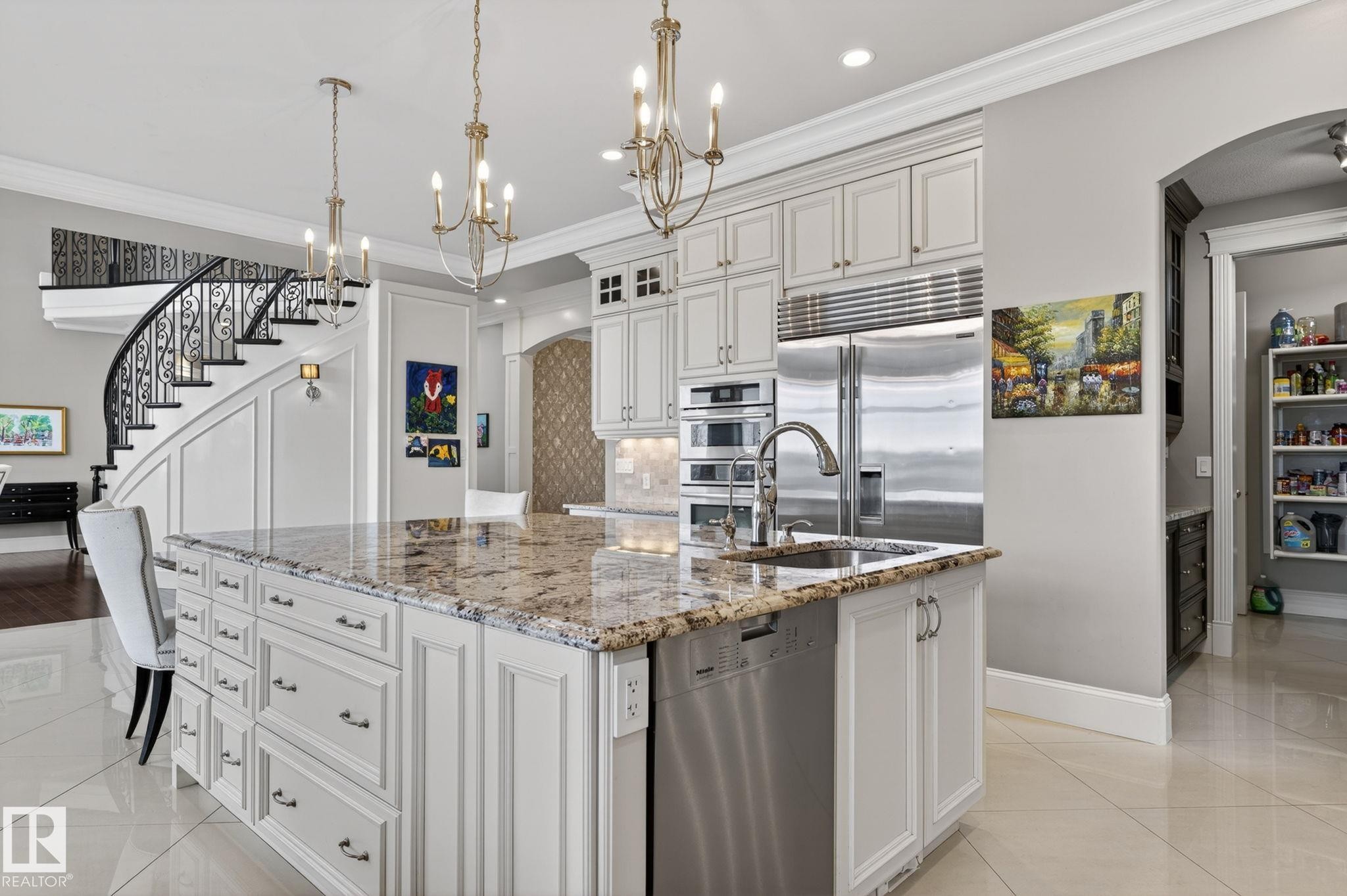 A spacious kitchen featuring a large island with a sink and granite countertop, stainless steel appliances, and white cabinetry - 1413 Woodward Crescent, Edmonton, AB - Indoor Photo Showing Kitchen With Upgraded Kitchen