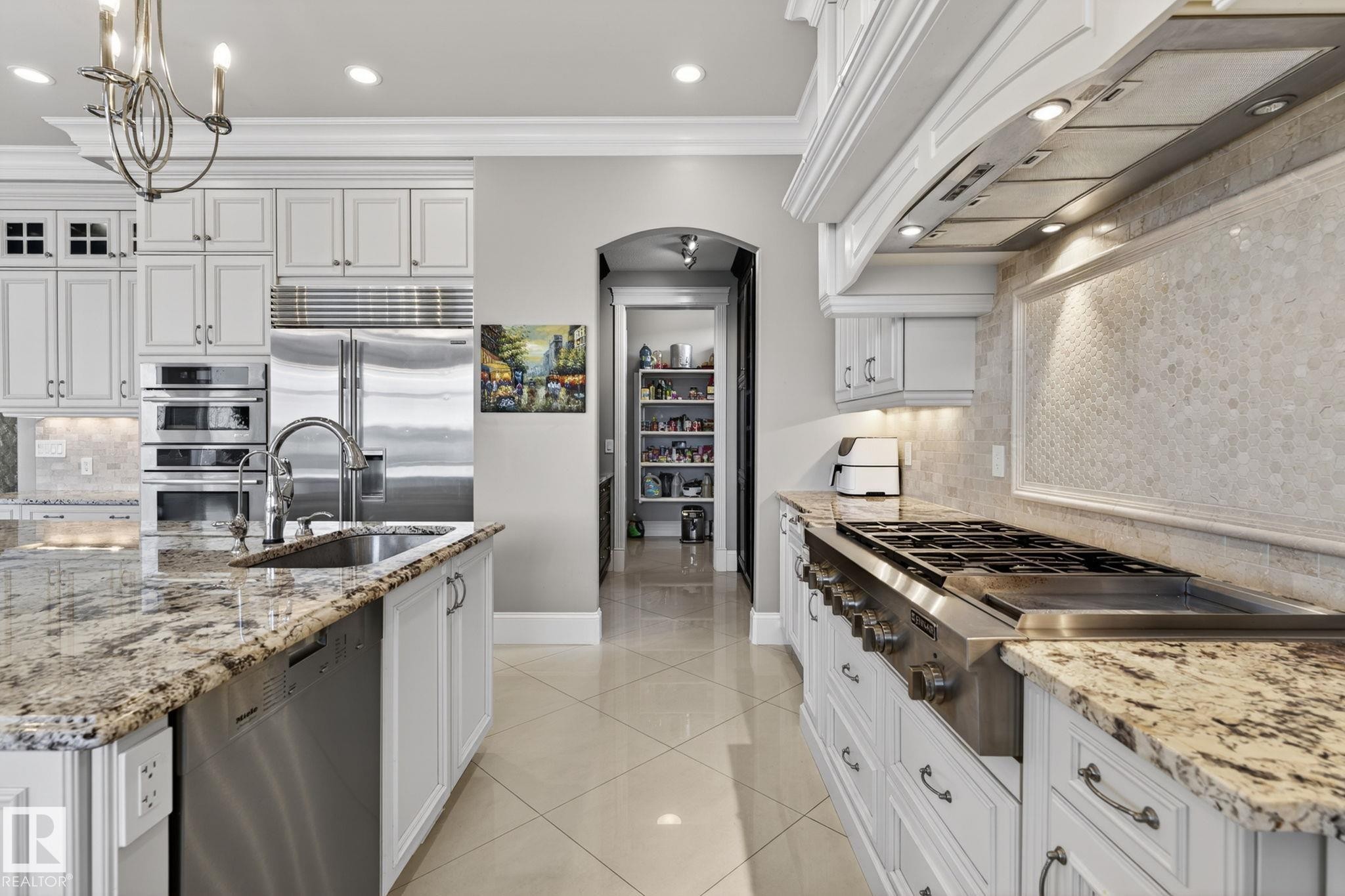 The kitchen features white cabinetry, granite countertops, and stainless steel appliances including a large refrigerator, double ovens, and a gas range - 1413 Woodward Crescent, Edmonton, AB - Indoor Photo Showing Kitchen With Upgraded Kitchen