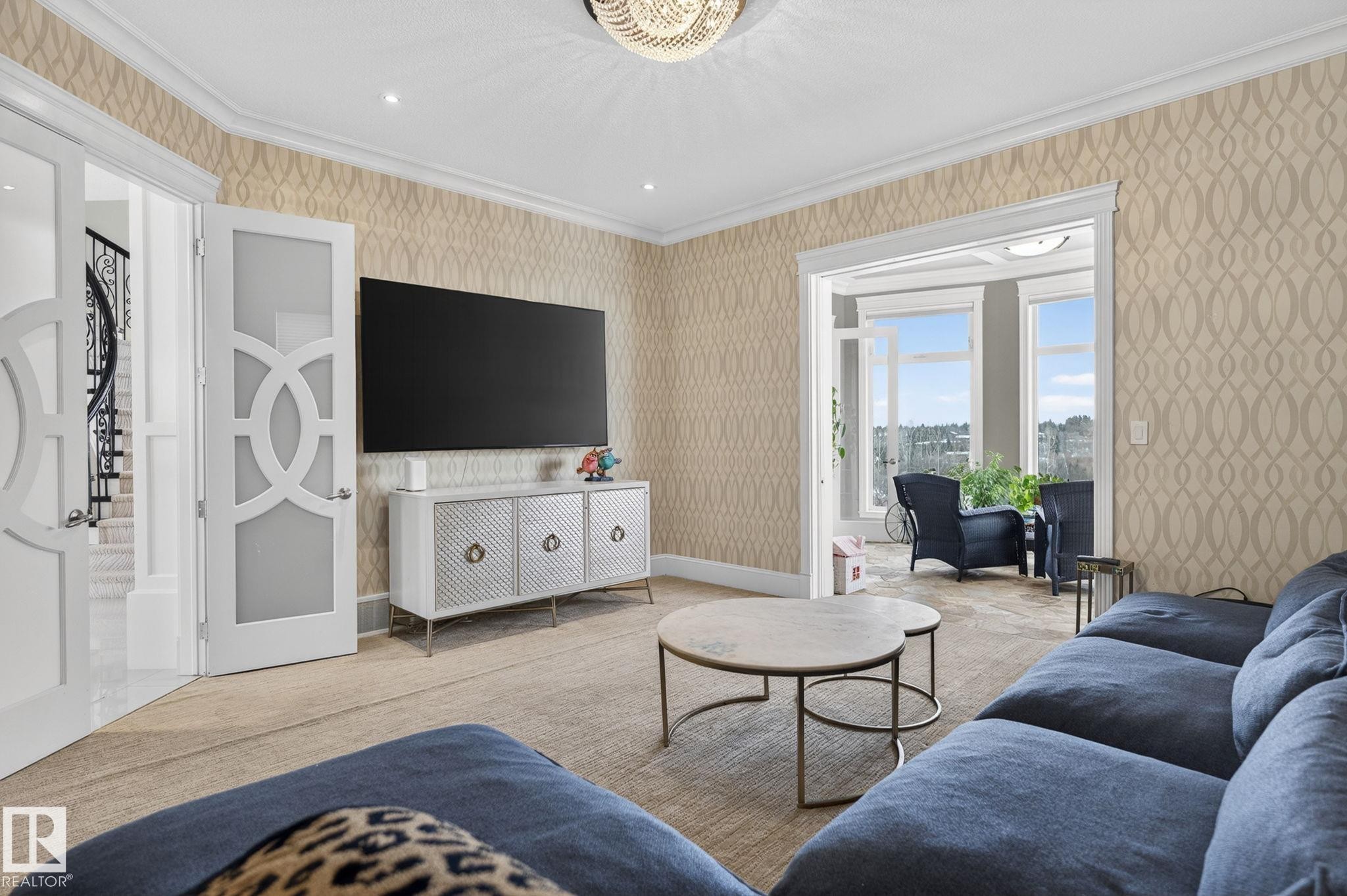 This living area showcases patterned wallpaper, crown molding, and a chandelier light fixture - 1413 Woodward Crescent, Edmonton, AB - Indoor Photo Showing Living Room