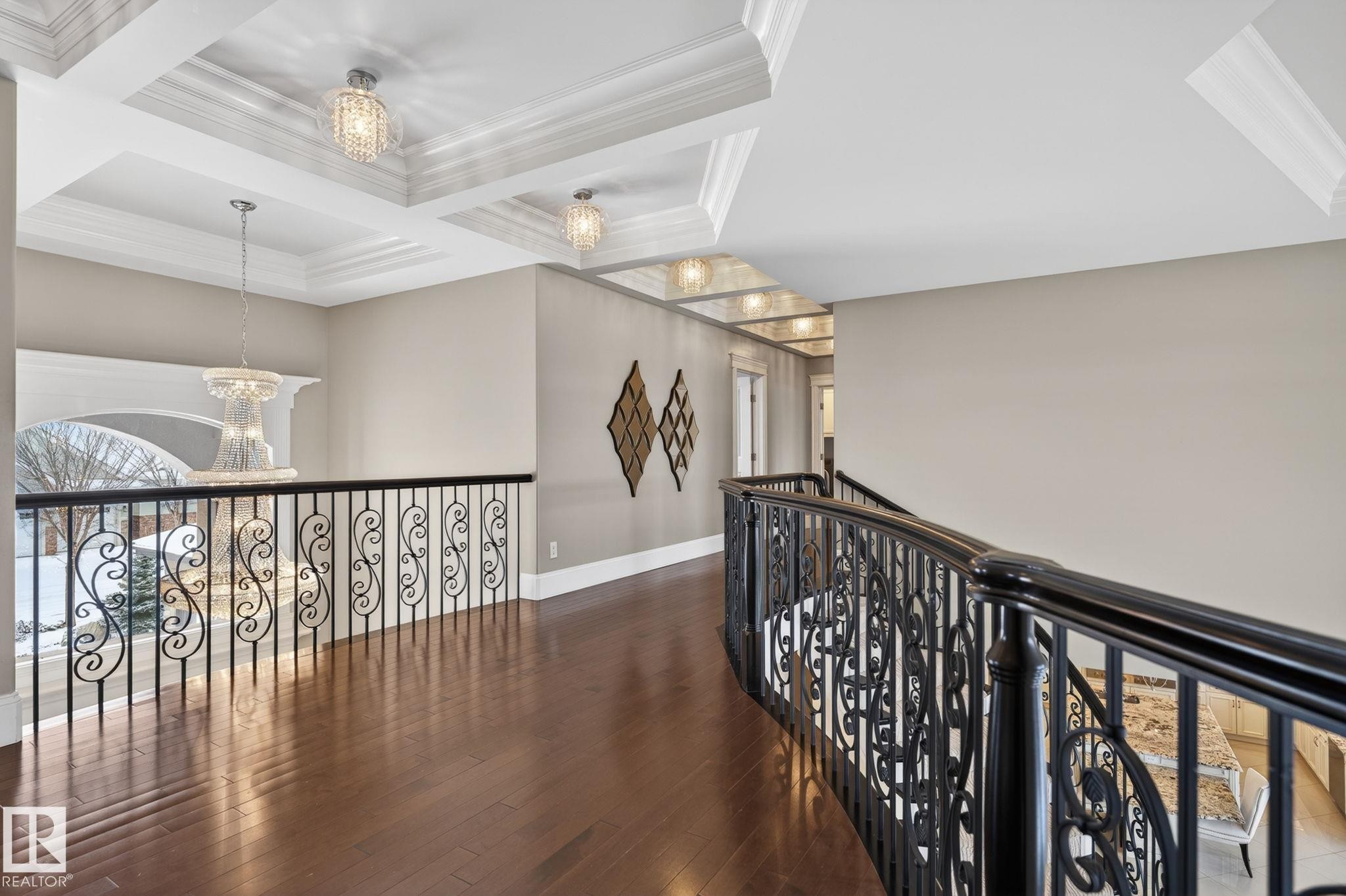 This elegant hallway features rich hardwood flooring and decorative metal railings with ornate scrollwork - 1413 Woodward Crescent, Edmonton, AB - Indoor Photo Showing Other Room