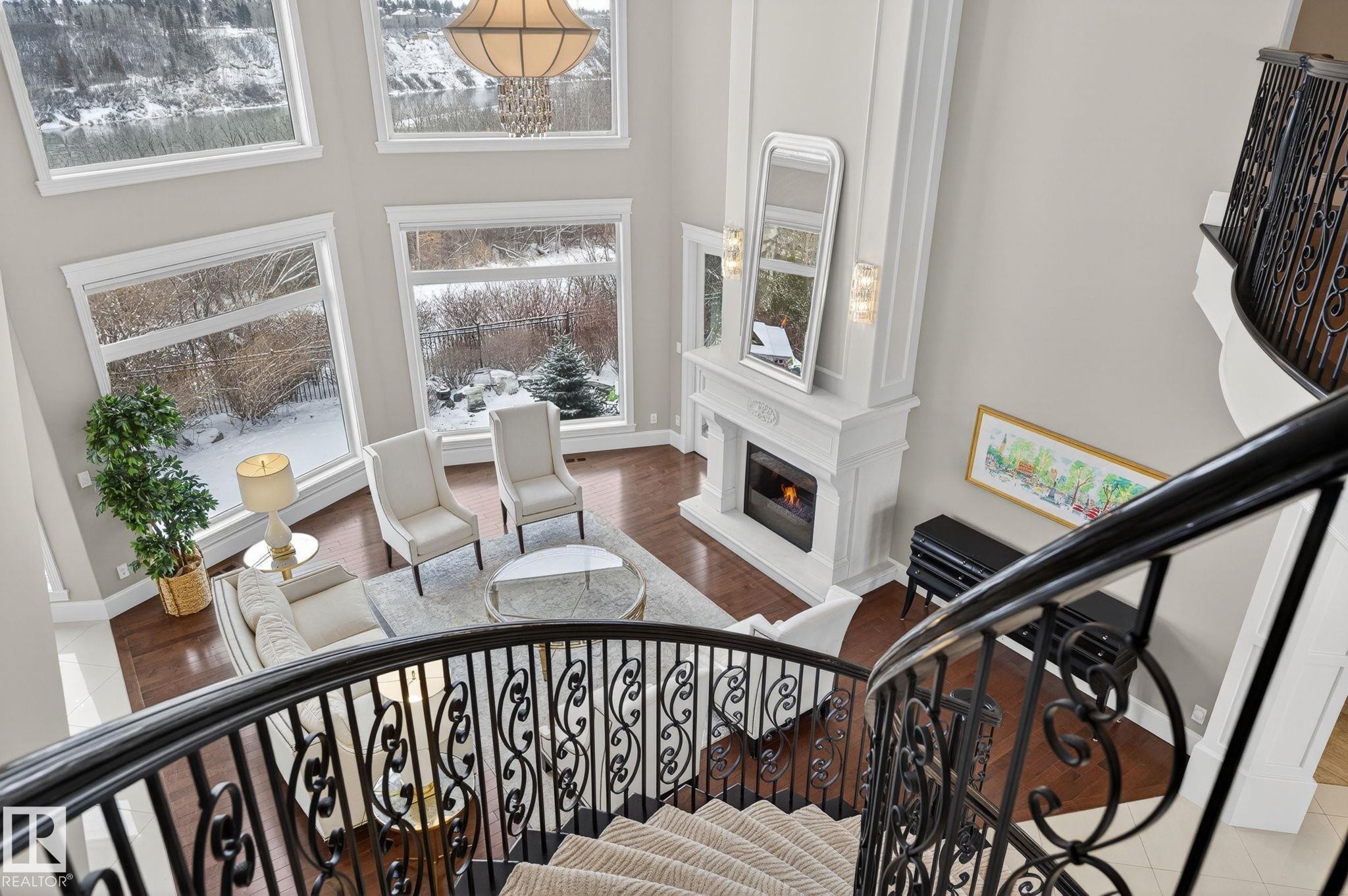 Grand living room featuring hardwood floors, a fireplace with a white mantel, and extensive windows with views of the outdoors - 1413 Woodward Crescent, Edmonton, AB - Indoor Photo Showing Other Room With Fireplace
