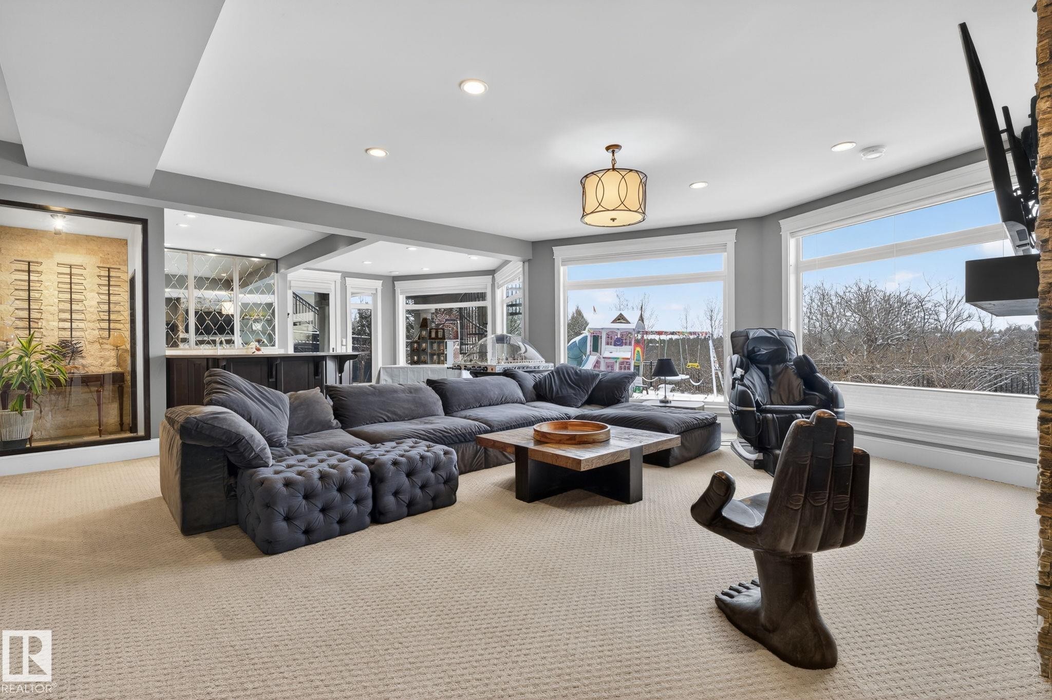 Spacious living area featuring light-colored carpeting, a recessed ceiling with lighting, and large windows offering exterior views - 1413 Woodward Crescent, Edmonton, AB - Indoor