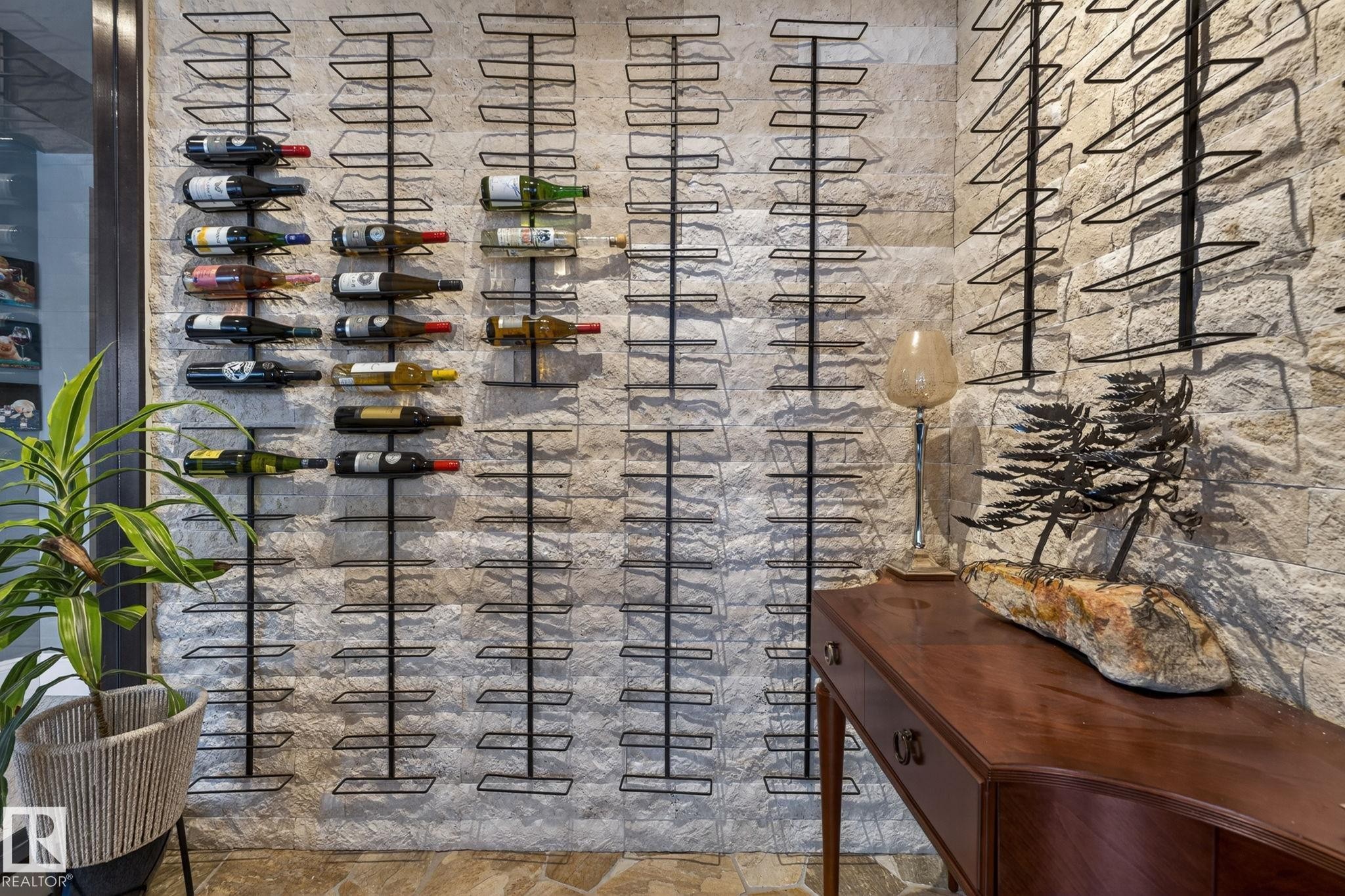 Dedicated wine storage area featuring a stone accent wall, integrated wine racks, and a wood console table - 1413 Woodward Crescent, Edmonton, AB - Photo Showing Other Room