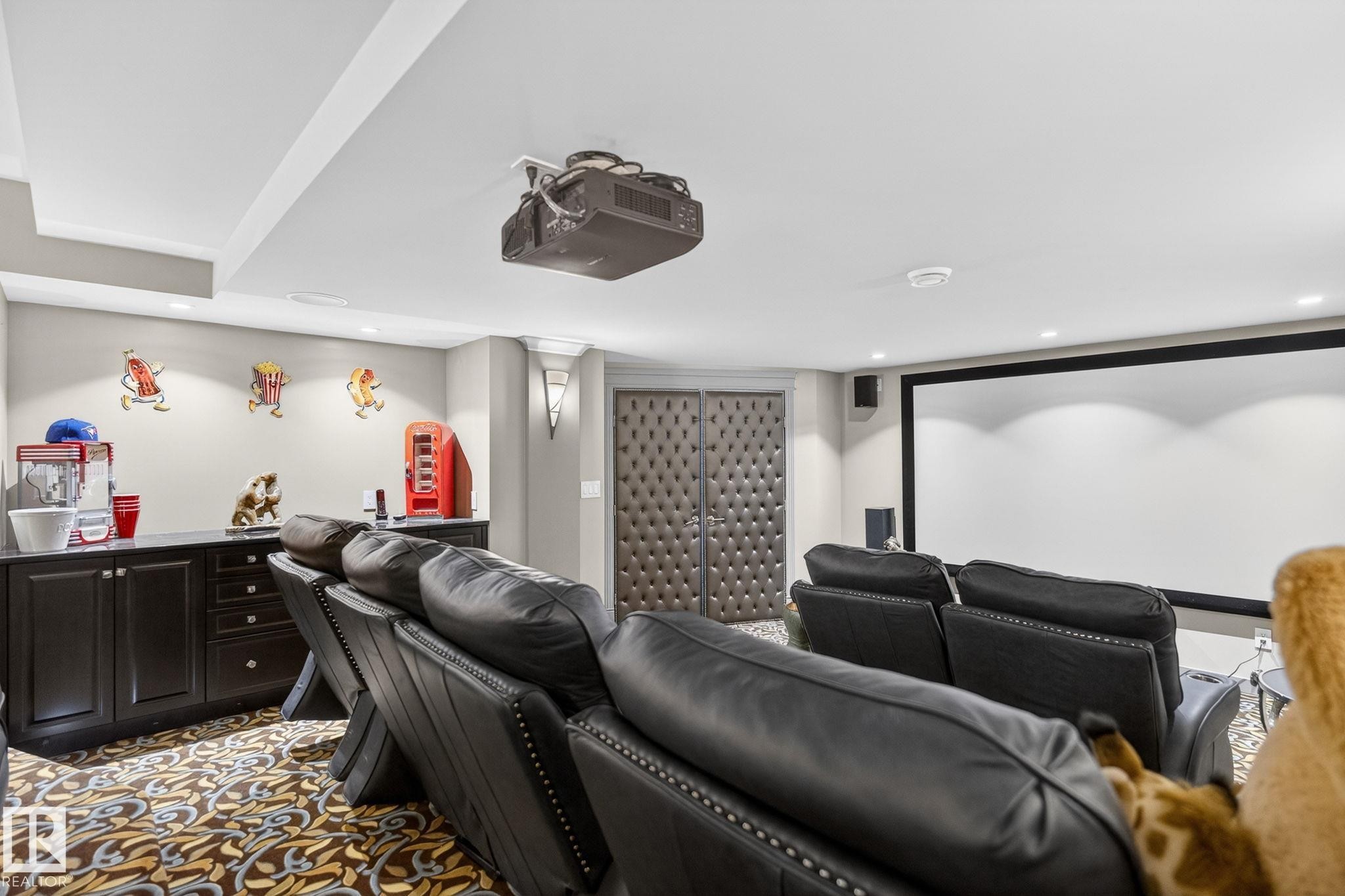 The property features a dedicated media room with a large projection screen, recessed lighting, and a dark wood wet bar with a countertop - 1413 Woodward Crescent, Edmonton, AB - Indoor