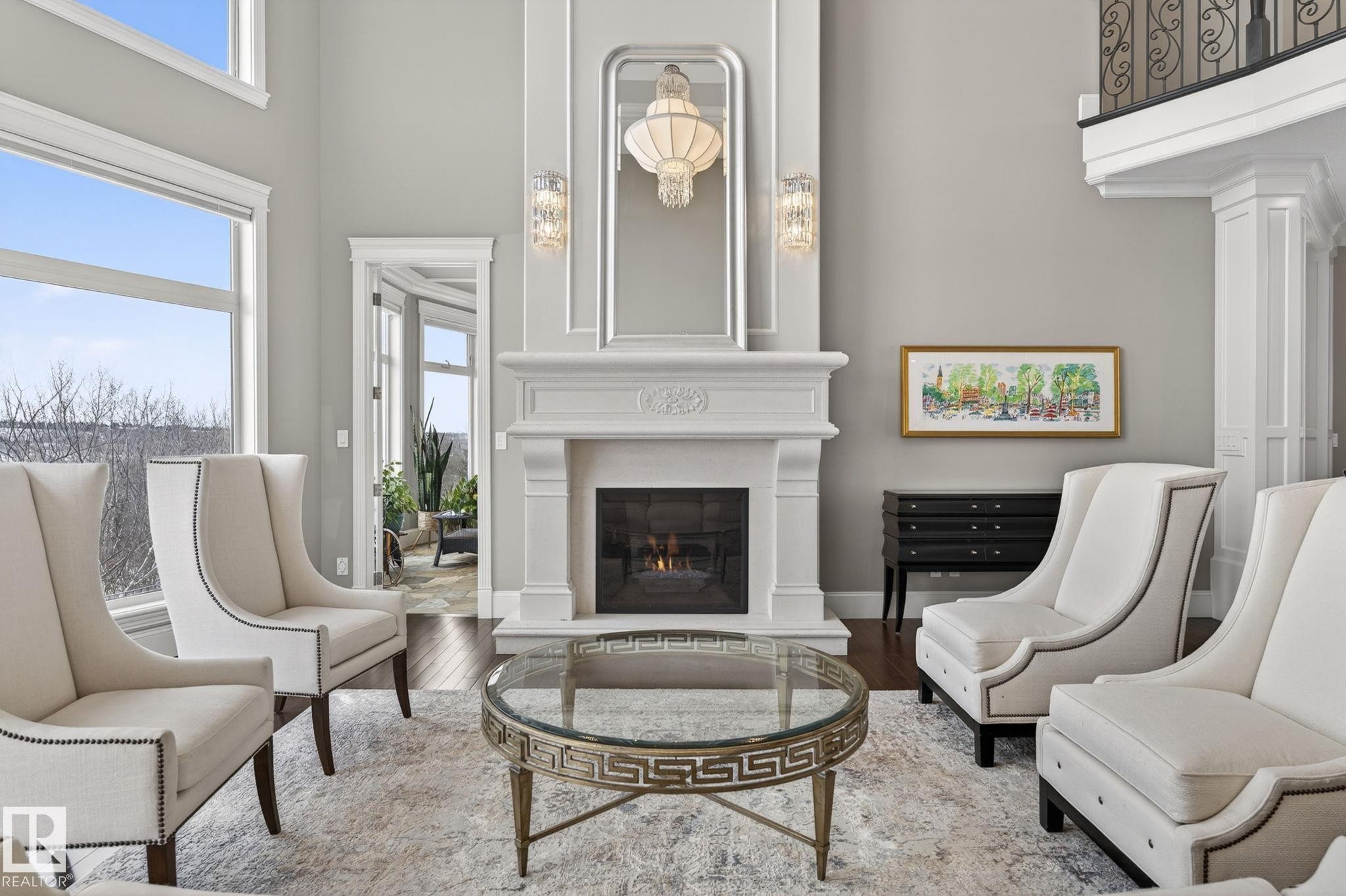 The living area features a grand fireplace, large windows providing natural light, and hardwood floors - 1413 Woodward Crescent, Edmonton, AB - Indoor Photo Showing Living Room With Fireplace
