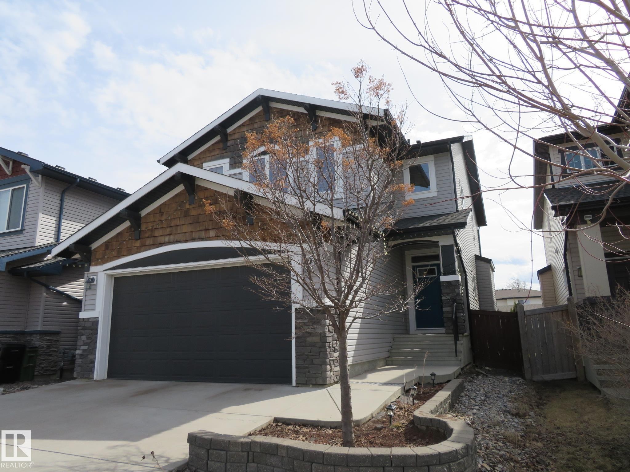 Contemporary two-story residence featuring light gray siding, dark wood shake accents, and stone detailing - 21807 97 Avenue, Edmonton, AB - Outdoor