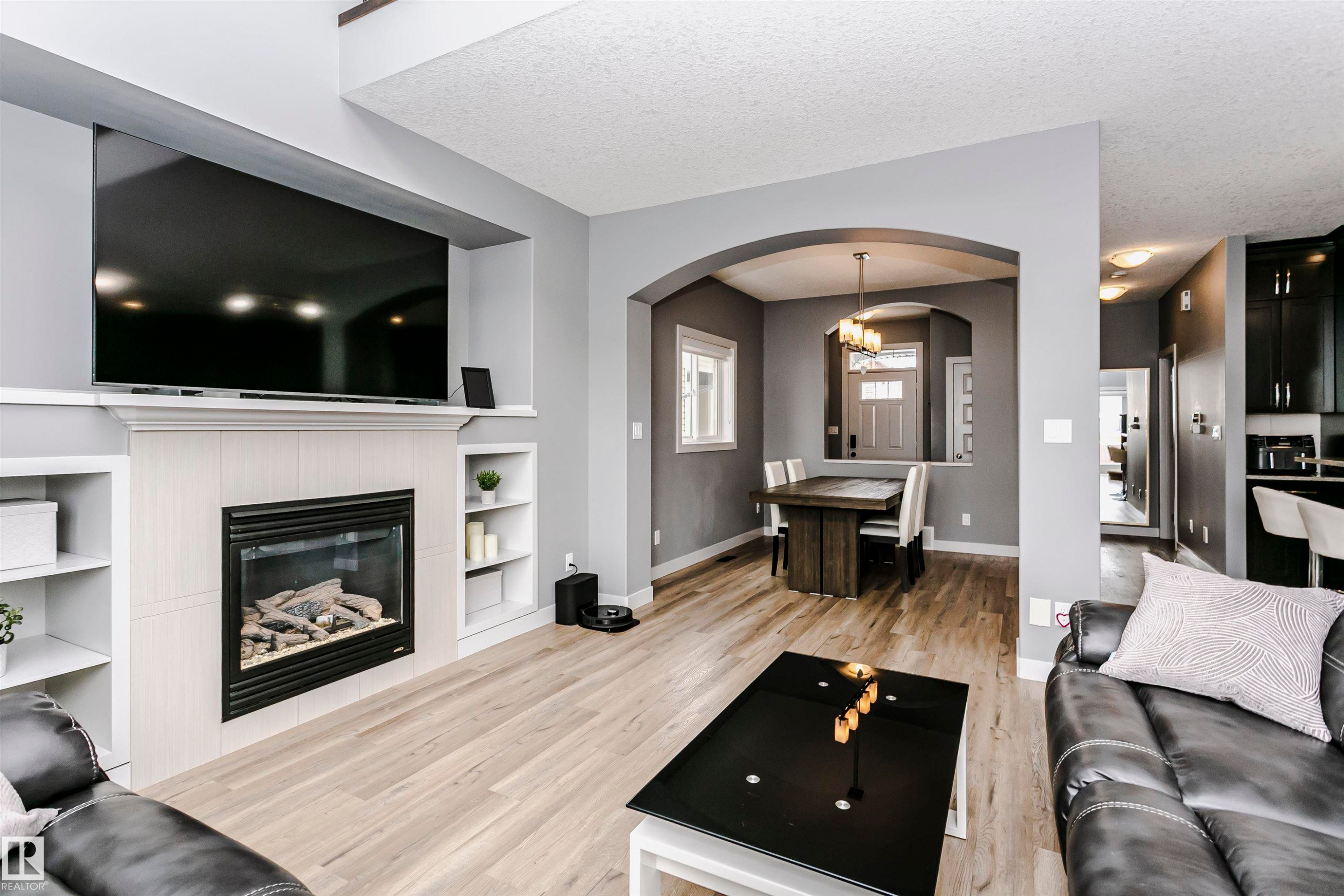 The property features an inviting living space with light-toned flooring and a built-in fireplace - 21807 97 Avenue, Edmonton, AB - Indoor Photo Showing Living Room With Fireplace