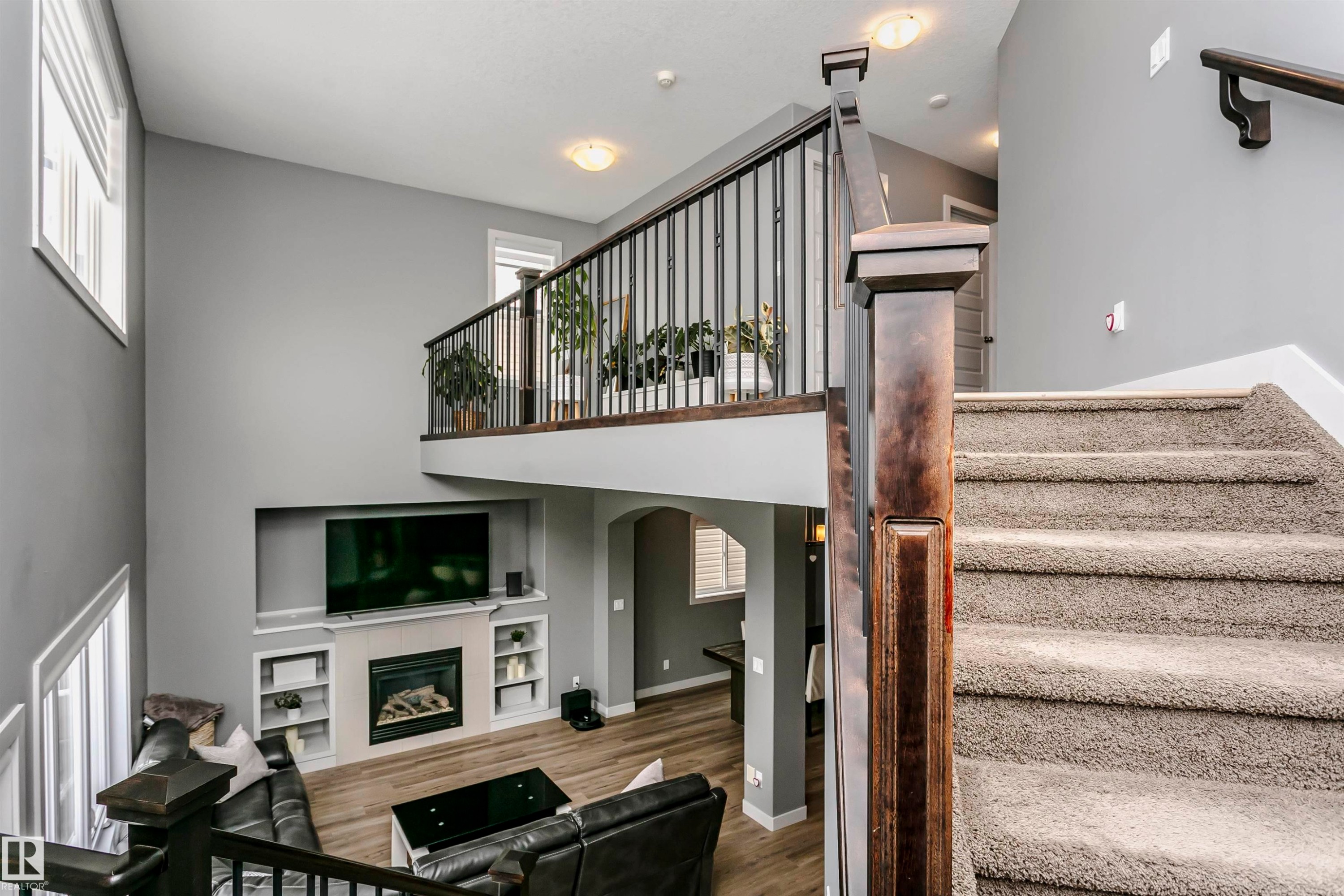 Inviting living space featuring a fireplace, a large built-in entertainment niche, and wood flooring - 21807 97 Avenue, Edmonton, AB - Indoor Photo Showing Other Room
