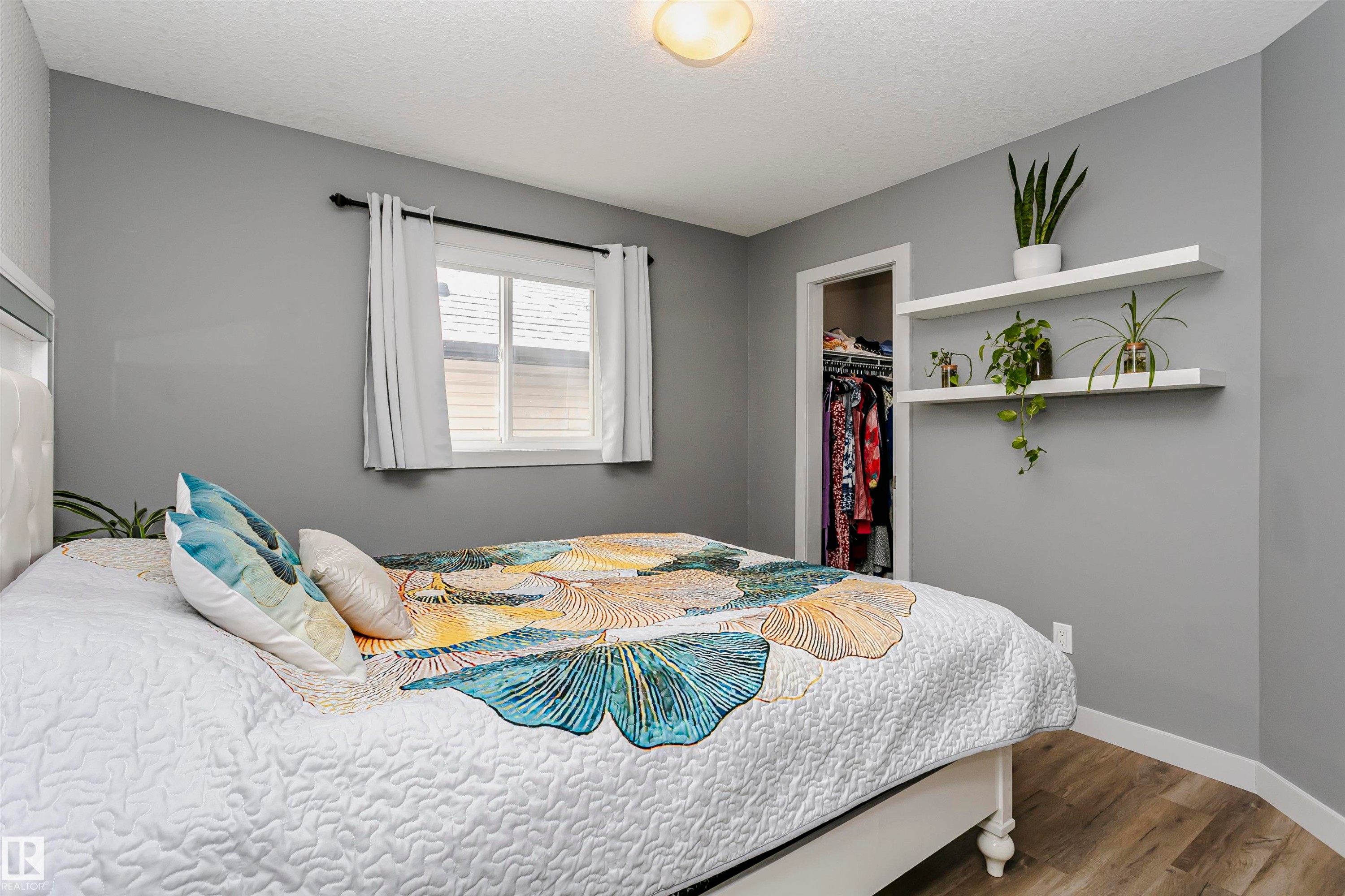 This room features a window with white curtains, a ceiling light fixture, and two white floating shelves - 21807 97 Avenue, Edmonton, AB - Indoor Photo Showing Bedroom