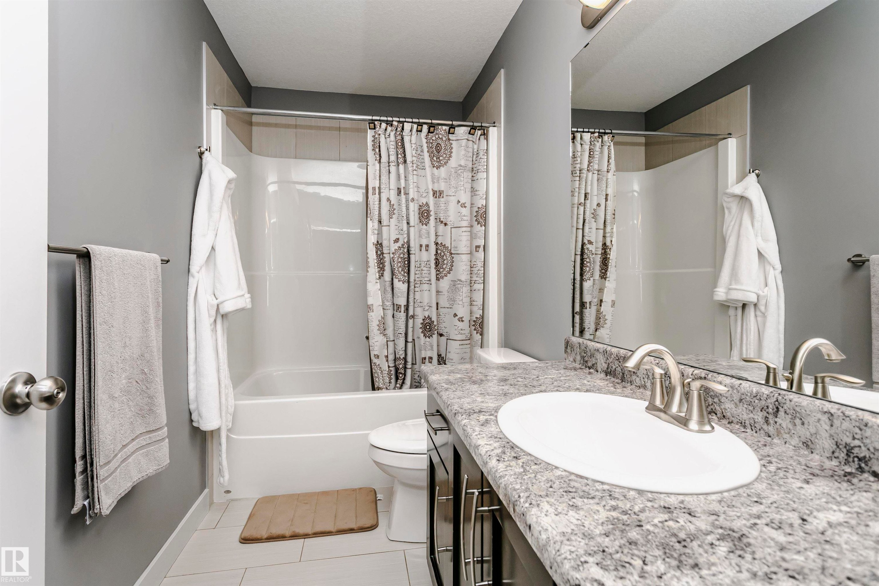 Bathroom featuring a vanity with a white sink, a grey speckled countertop, and a mirror - 21807 97 Avenue, Edmonton, AB - Indoor Photo Showing Bathroom