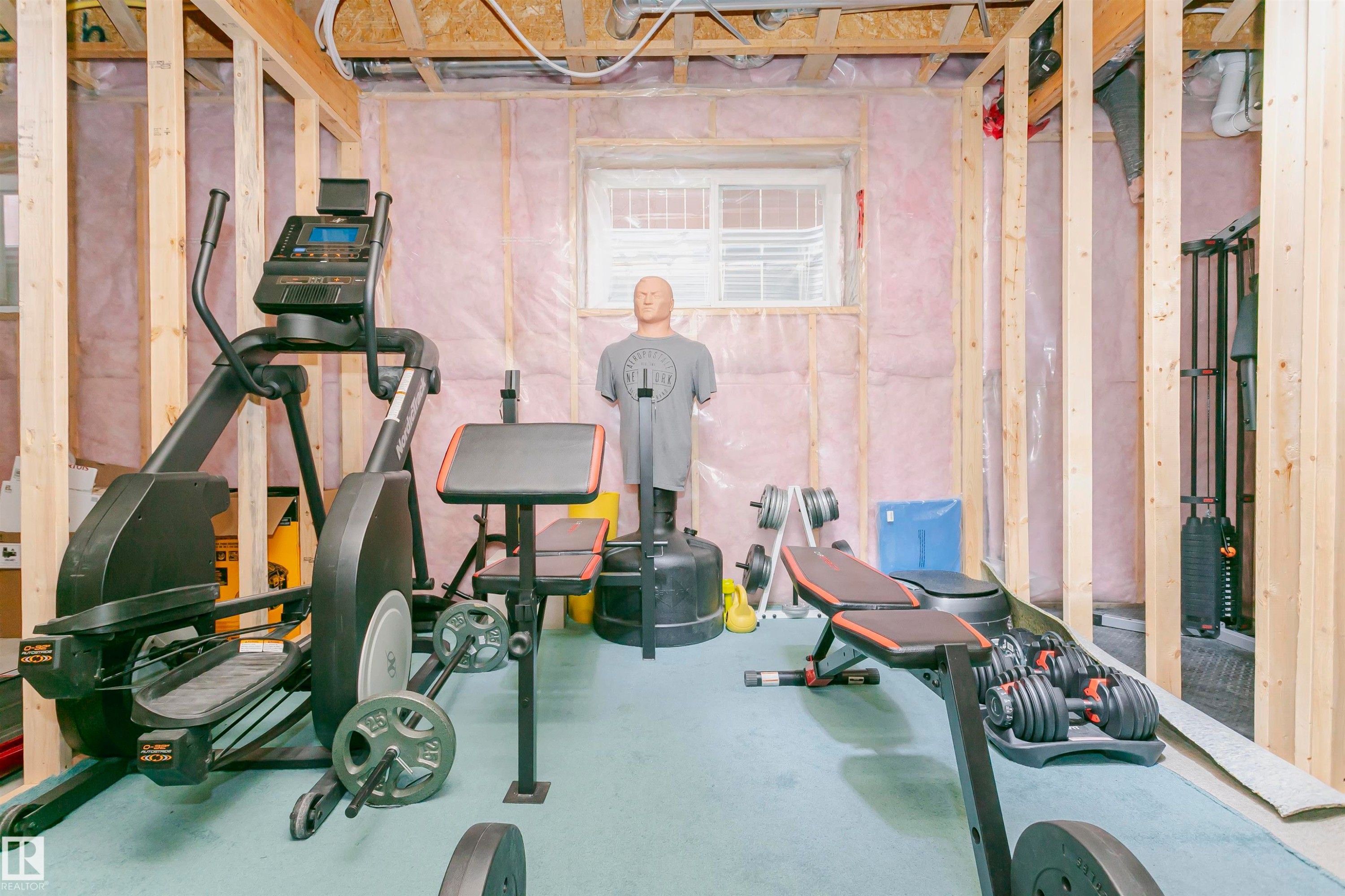 The unfinished basement provides an opportunity for customization, featuring exposed wooden framing, insulation, and a window for natural light - 21807 97 Avenue, Edmonton, AB - Indoor